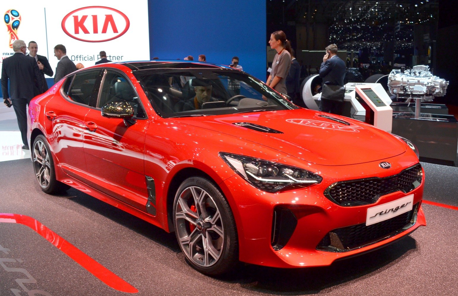 Red sporty sedan with LED headlights and prominent front grille