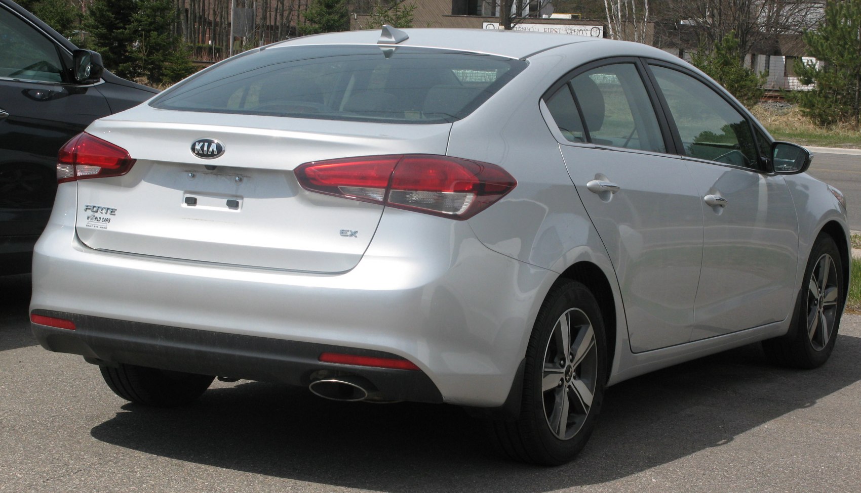 Rear view of a sedan highlighting tail lights, rear bumper, and alloy wheels.