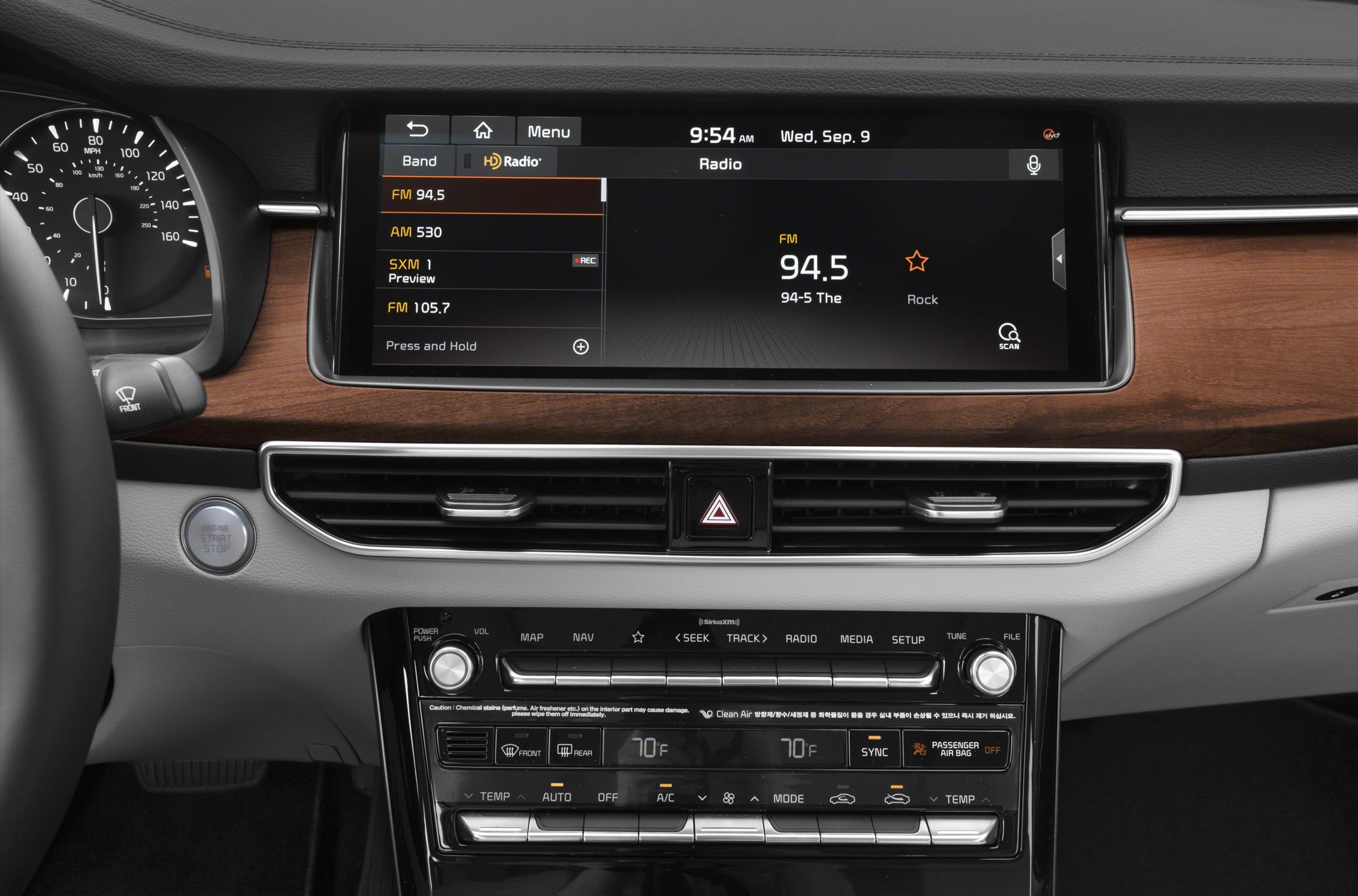Touchscreen infotainment and climate control system on a wood-trimmed dashboard