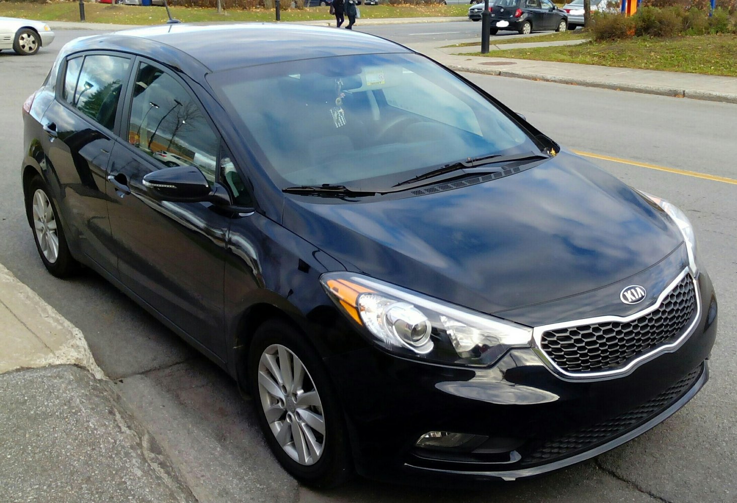 Black hatchback with focus on front headlight and grille