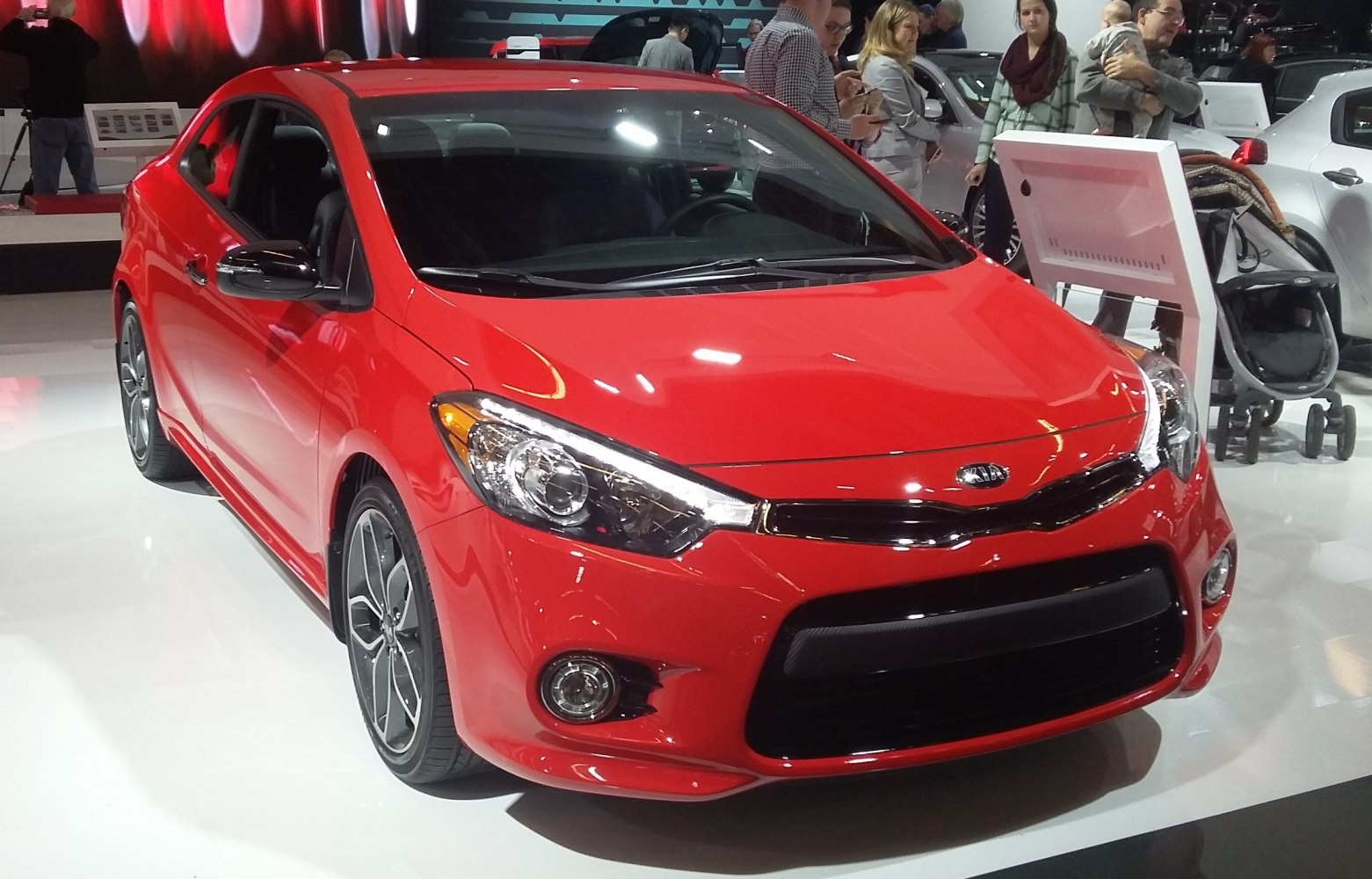 Sporty red coupe with sleek headlights and alloy wheels