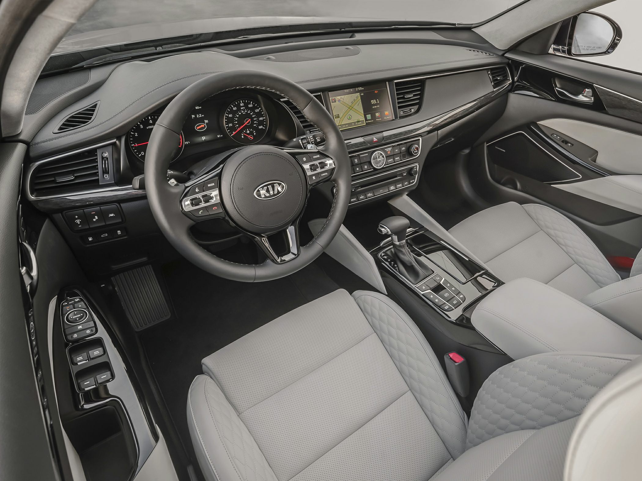 Modern car interior with dashboard, touchscreen, steering wheel, and quilted seats