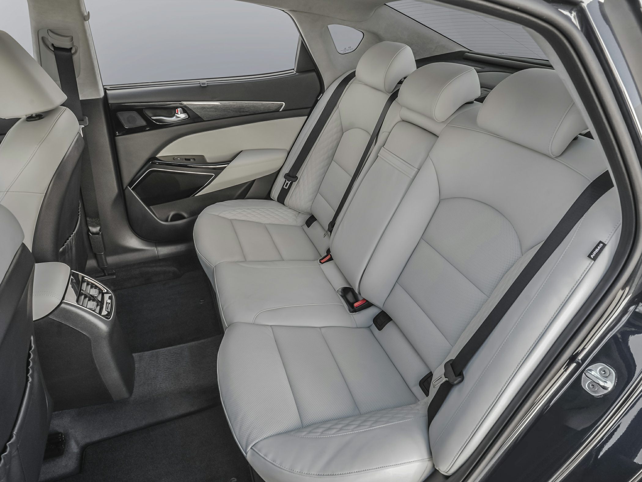 Spacious rear seats with grey leather upholstery and detailed stitching.