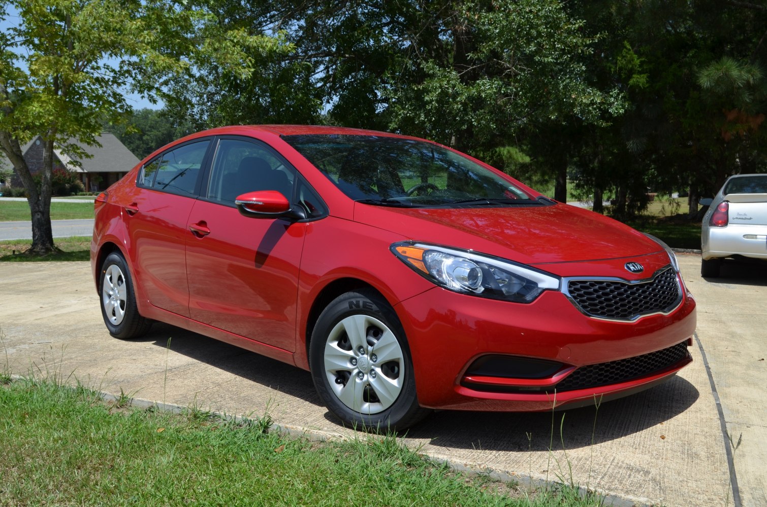 Red compact sedan with sleek headlights and honeycomb grille