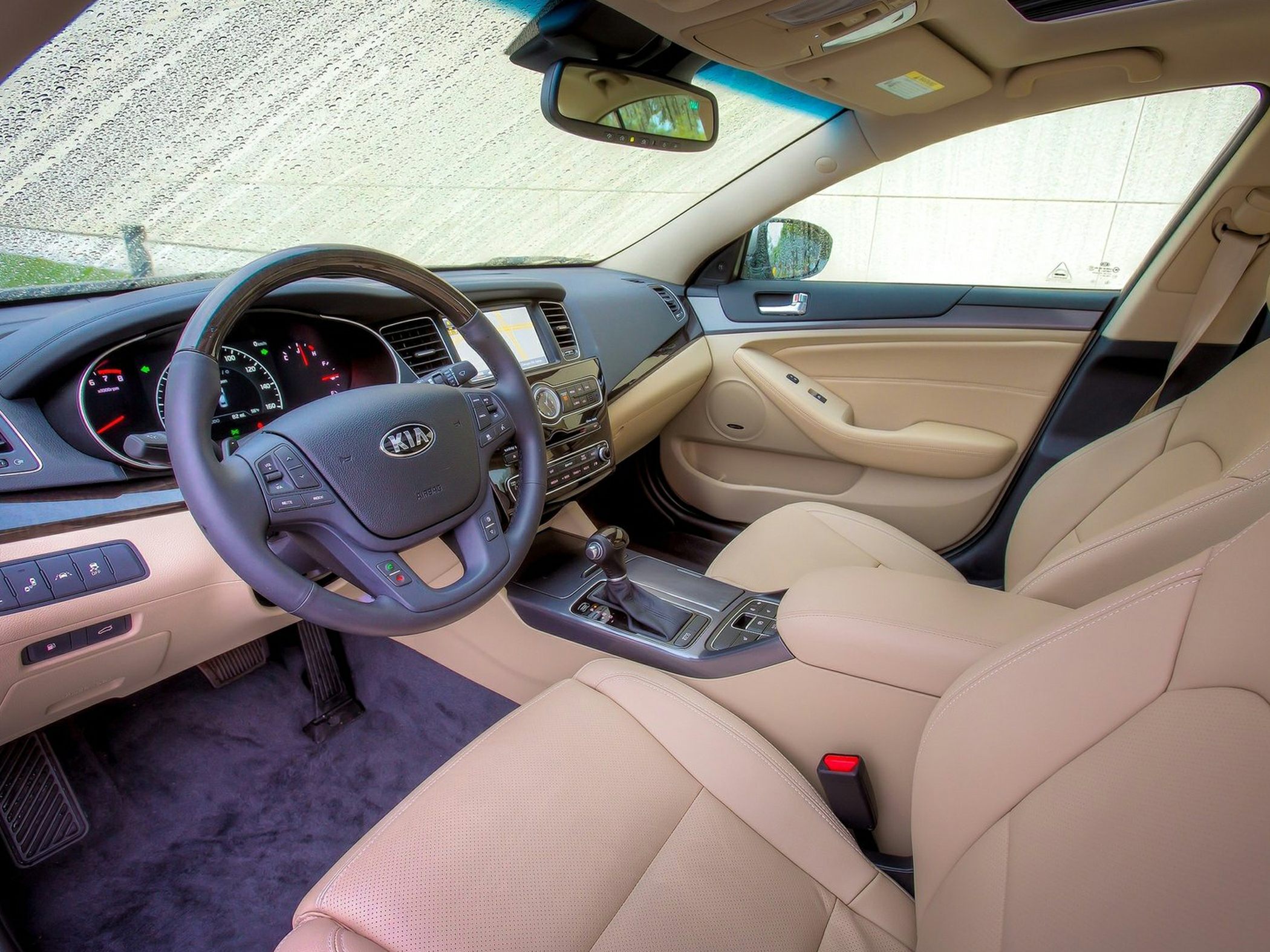 Beige leather interior with multifunction steering wheel and touchscreen dashboard.