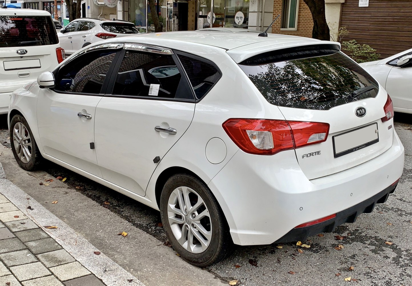 White hatchback with tinted windows and rear spoiler