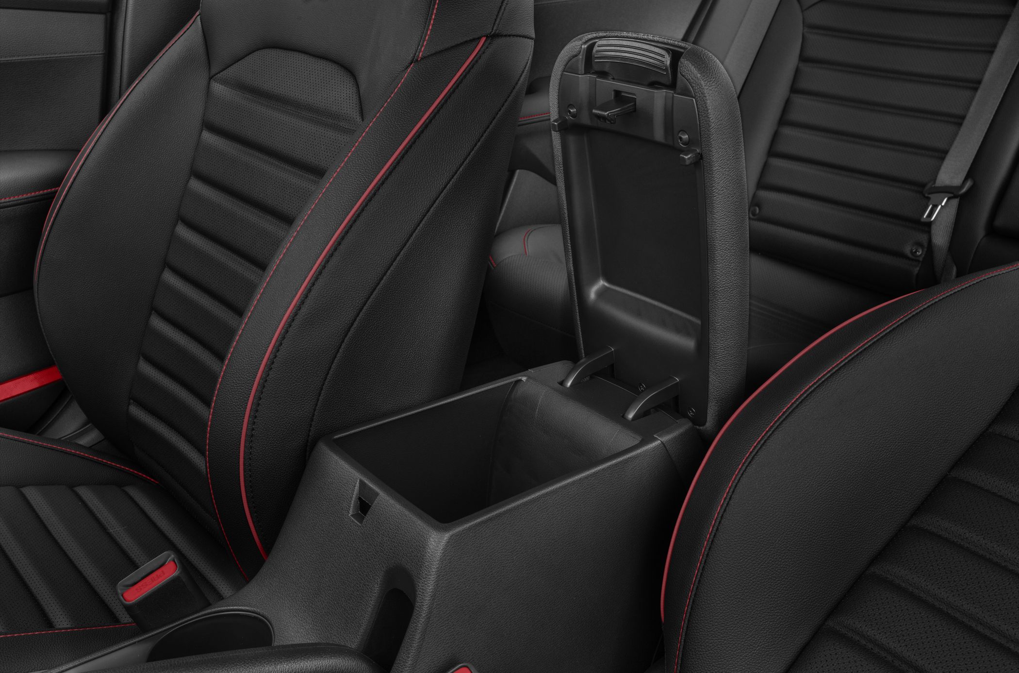 Center console storage compartment with black leather seats and red stitching