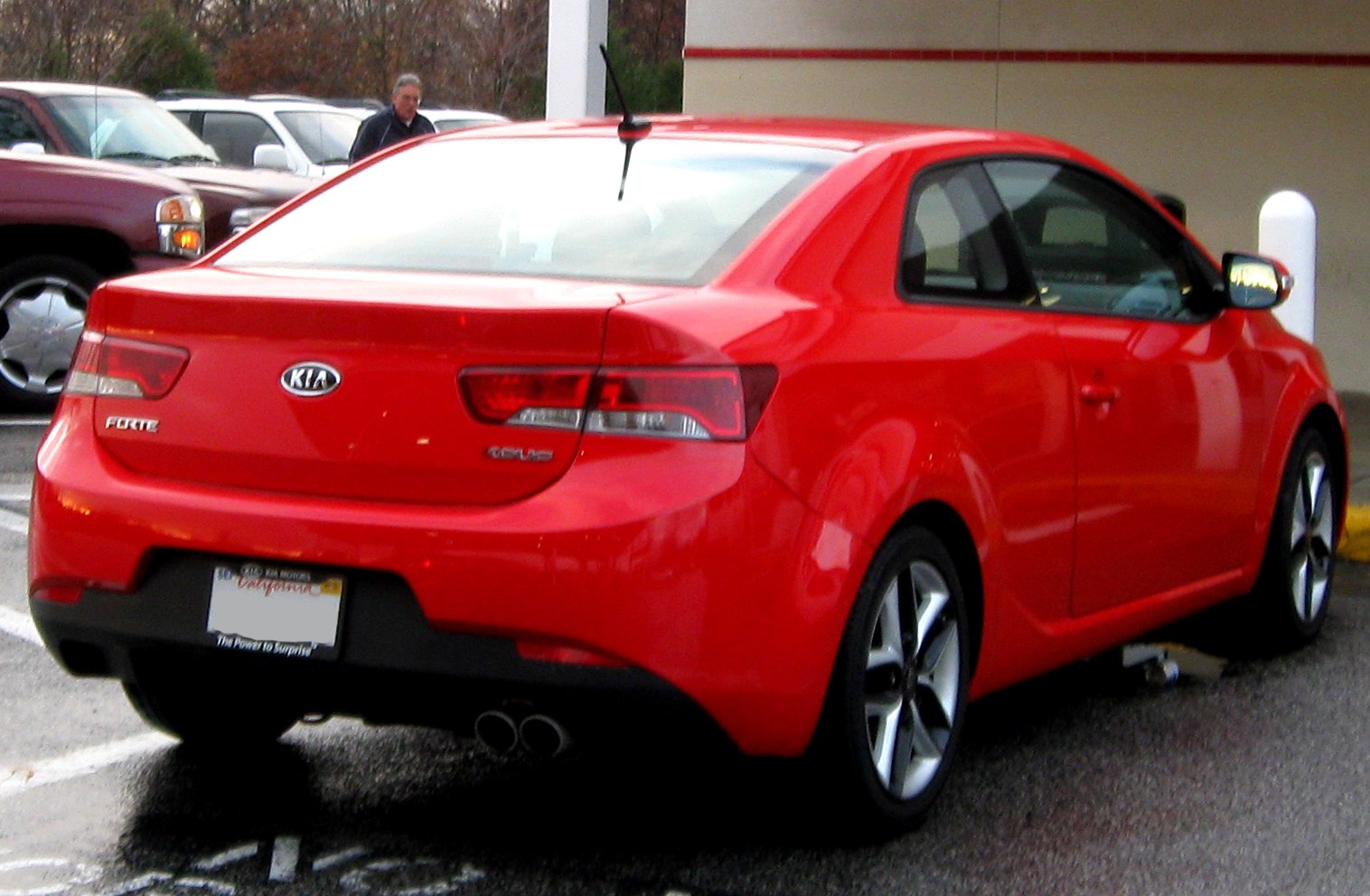 Red sporty two-door coupe with dual exhaust and distinct rear design