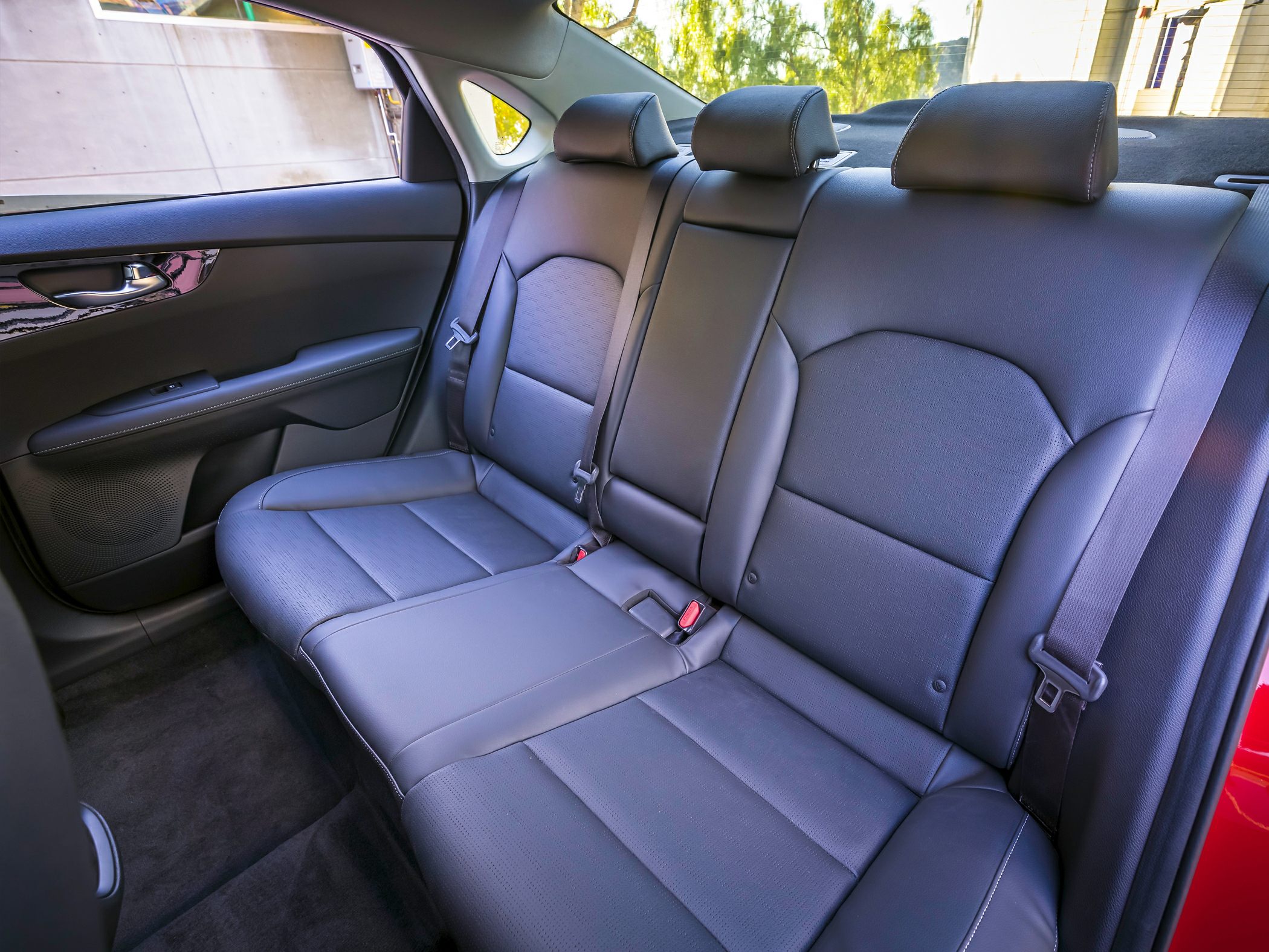 Black leather upholstered rear seat with three headrests and seatbelt.