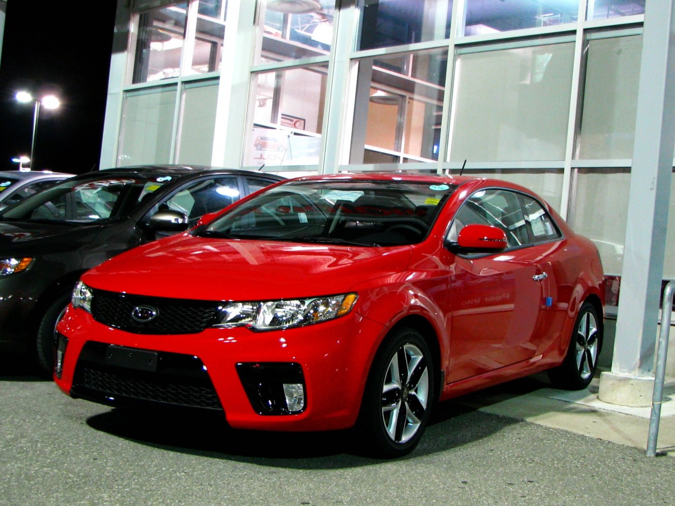 Aggressive front grille and alloy wheels on red sporty coupe