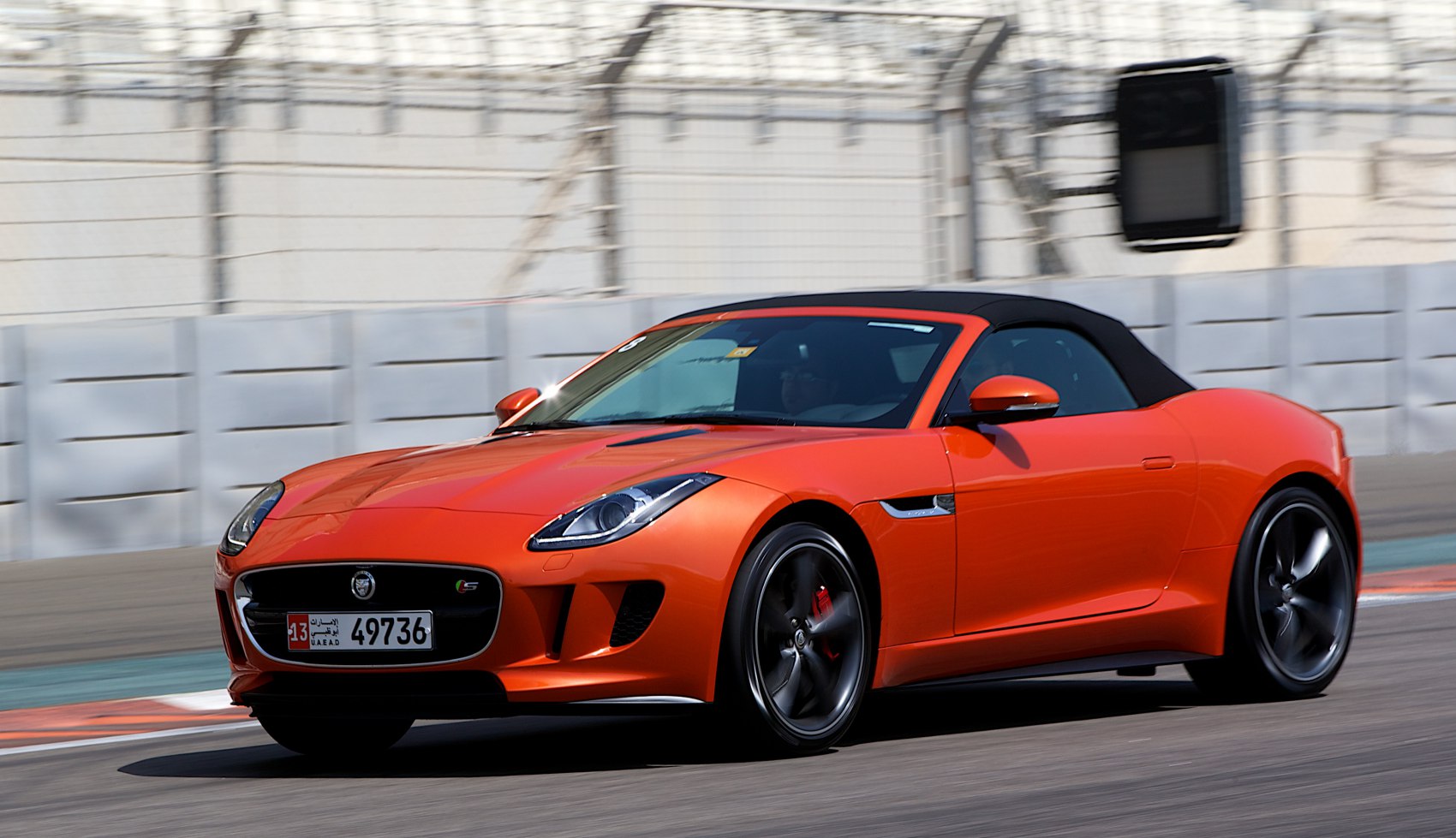 Front and side view of orange convertible with sporty wheels