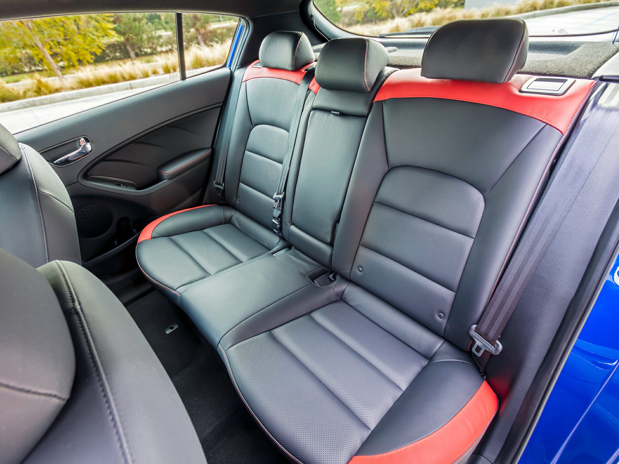 Rear black and red leather seats with headrests and seat belts