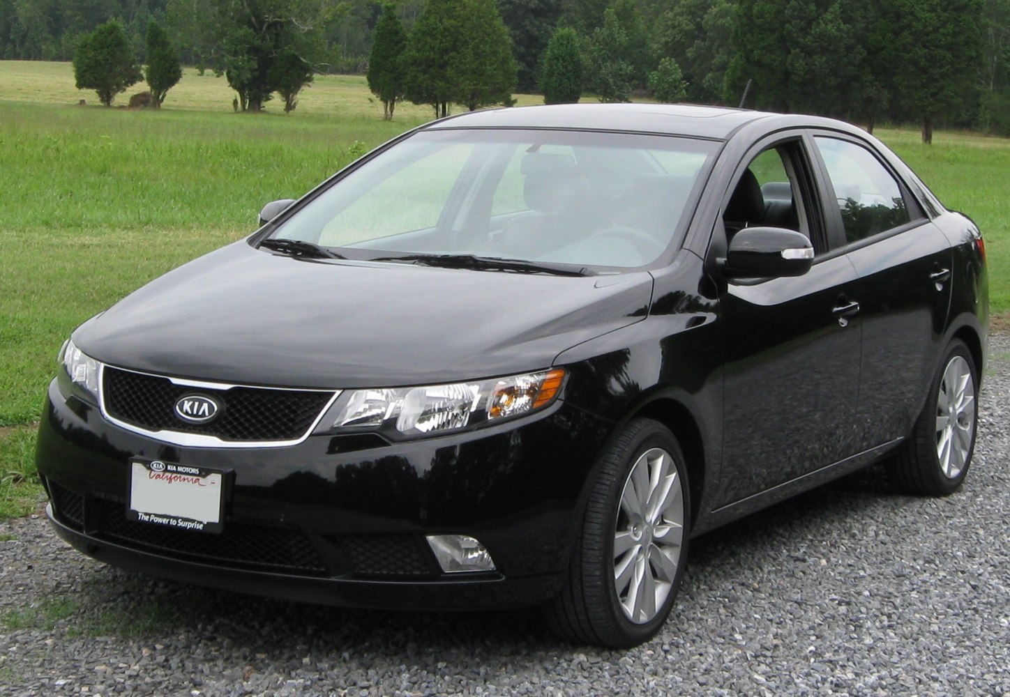 Front side view of black sedan with sharp headlights and alloy wheels