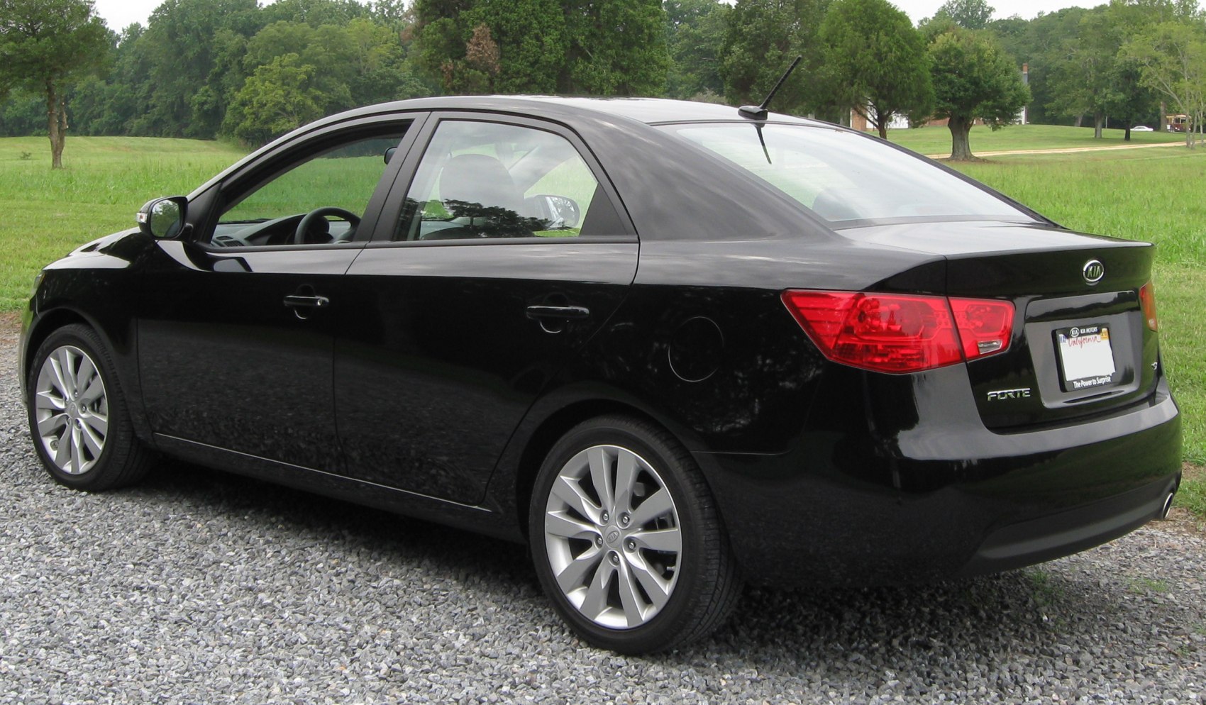 Rear and side view of a black sedan with alloy wheels.
