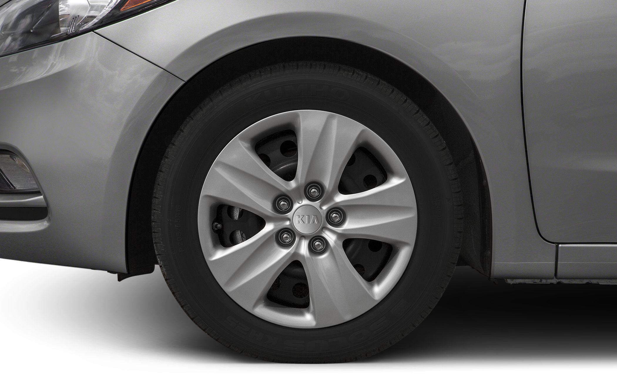Close-up of alloy wheel and tire with Kia logo hubcap.