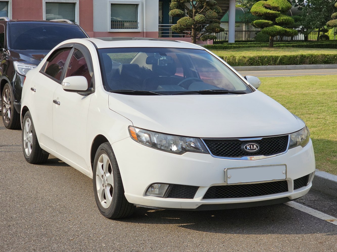 White sedan front angle featuring headlamps and grille