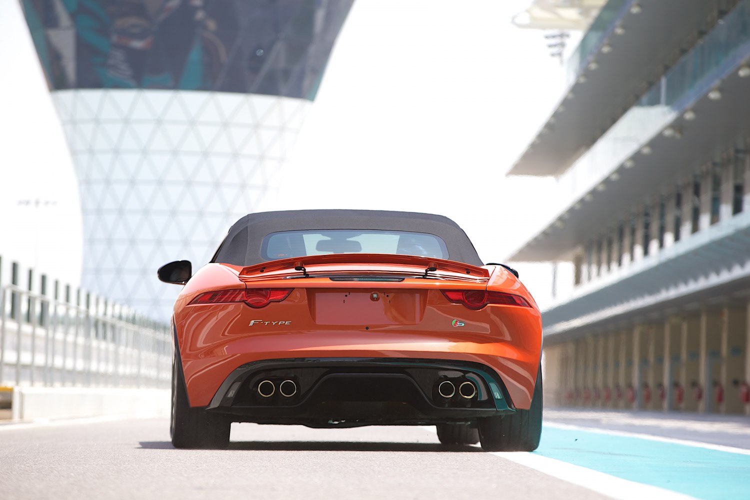 Rear view of convertible sports car with quad exhaust and spoiler
