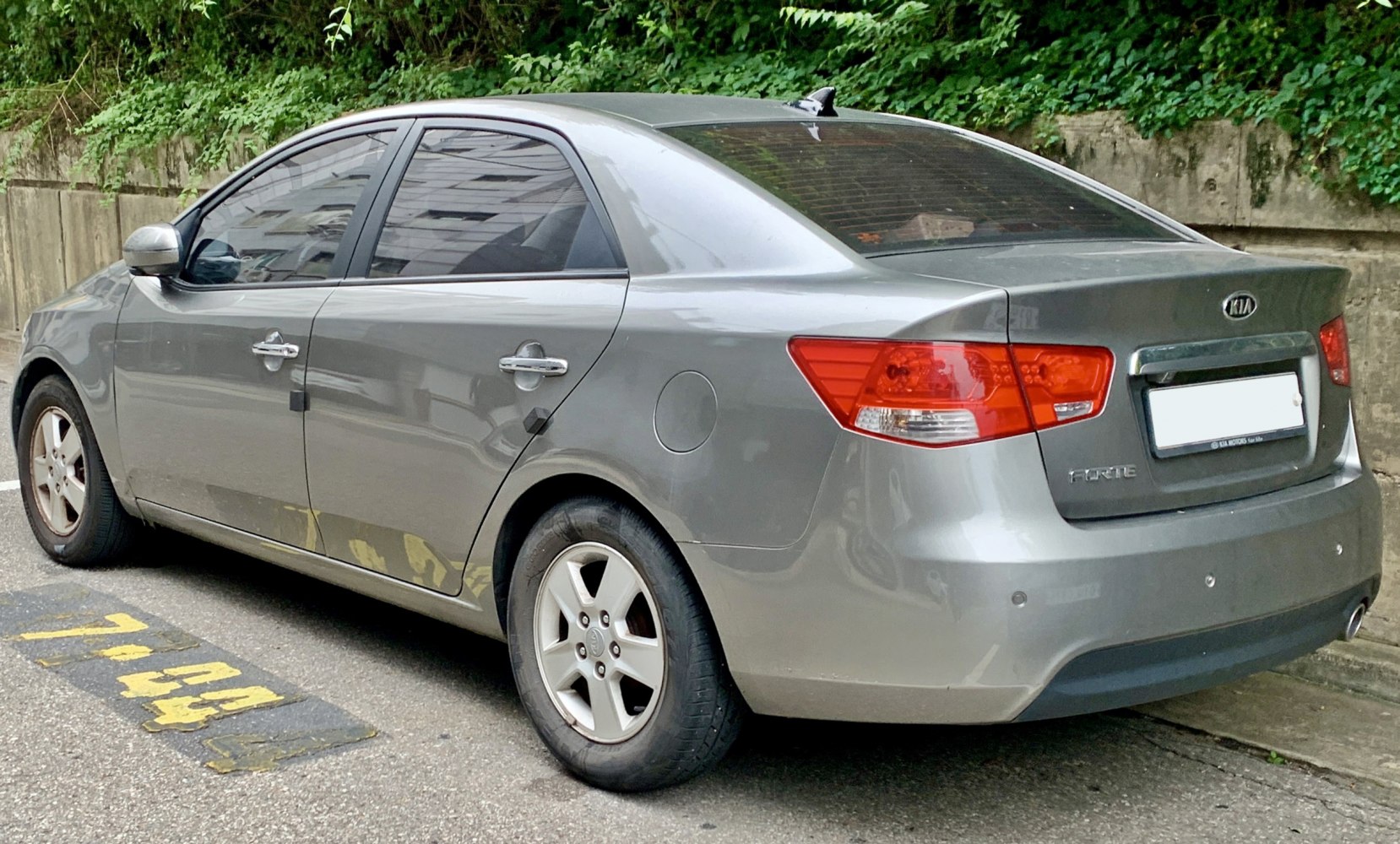 Rear side view of gray sedan with distinctive taillights and alloy wheels
