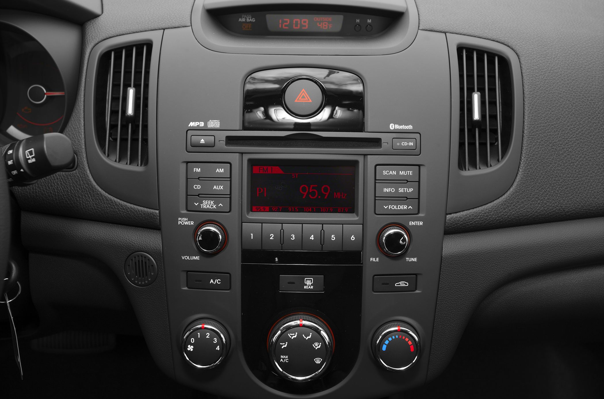 Car center console with radio, Bluetooth, CD player, and climate control knobs