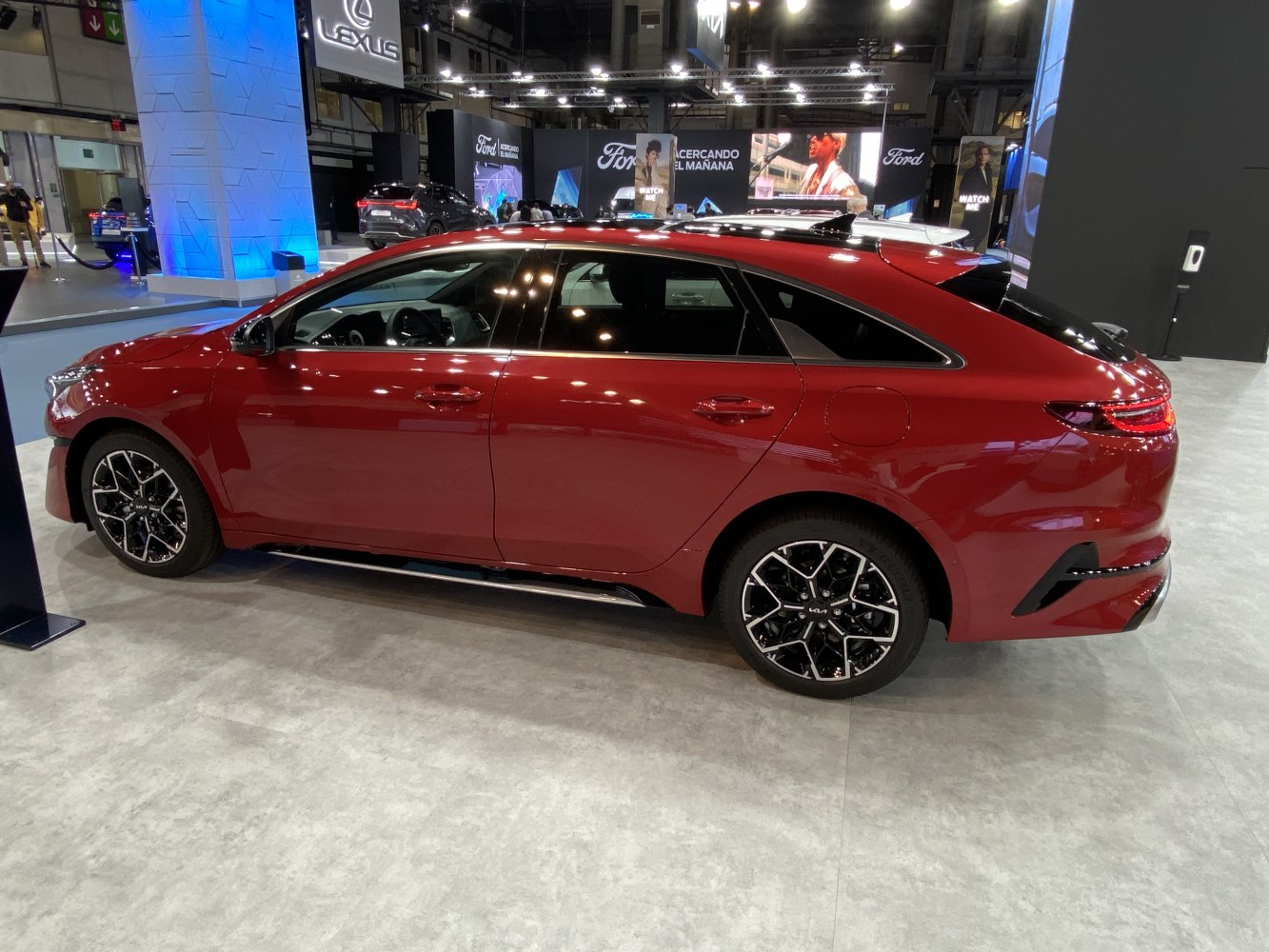 Red station wagon with black multi-spoke alloy wheels and panoramic sunroof
