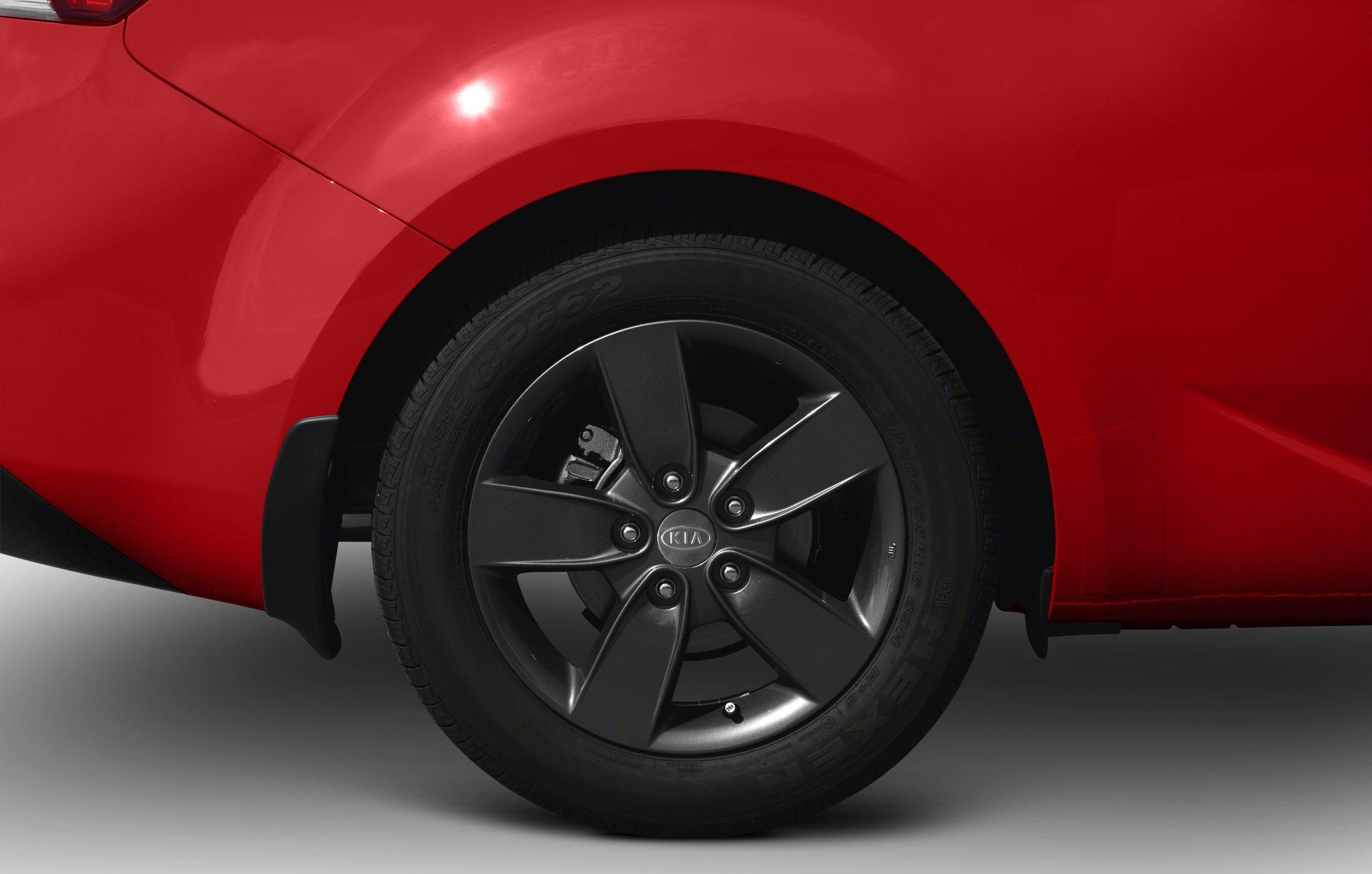 Black alloy wheel with multi-spoke design on red car panel