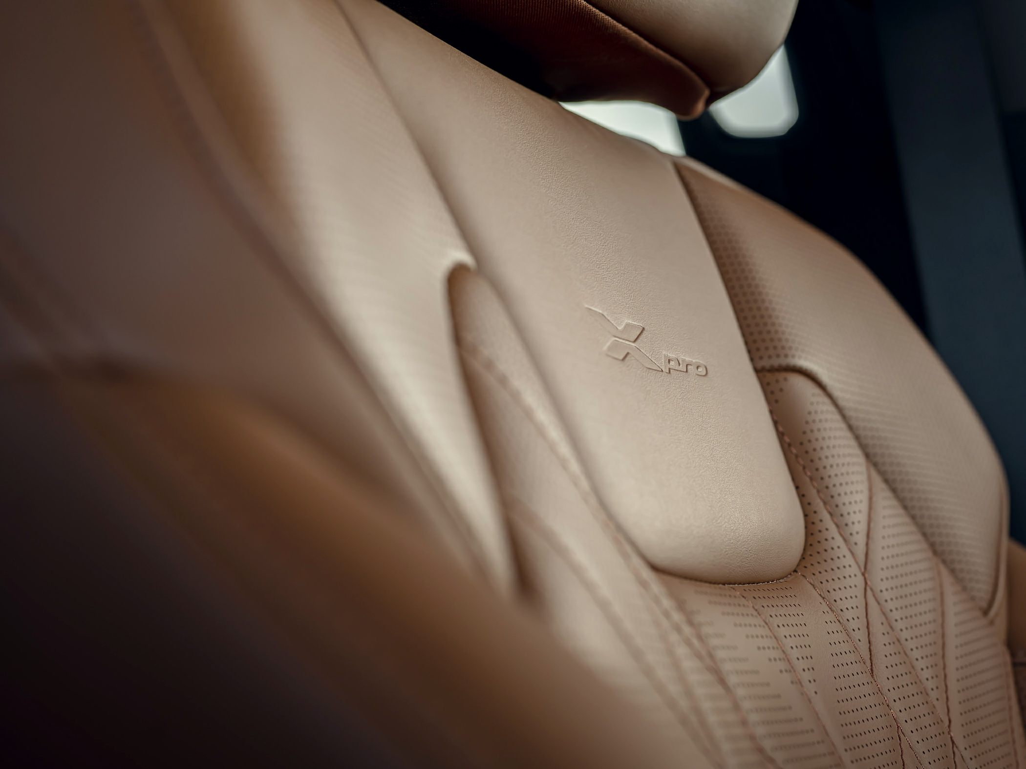 Brown leather perforated seat with X-Pro embossed branding