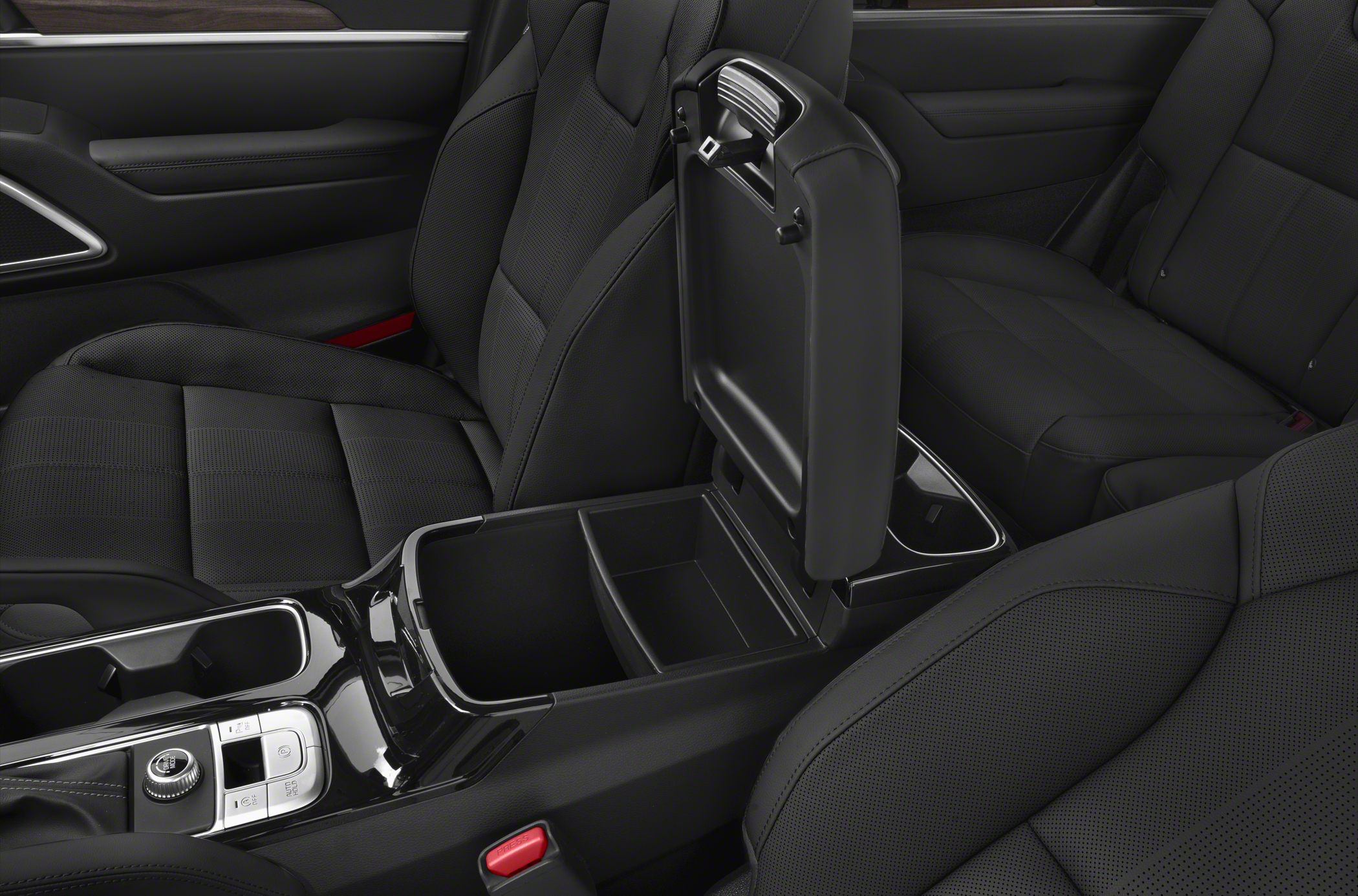 Center console with open storage compartment and black leather seats.