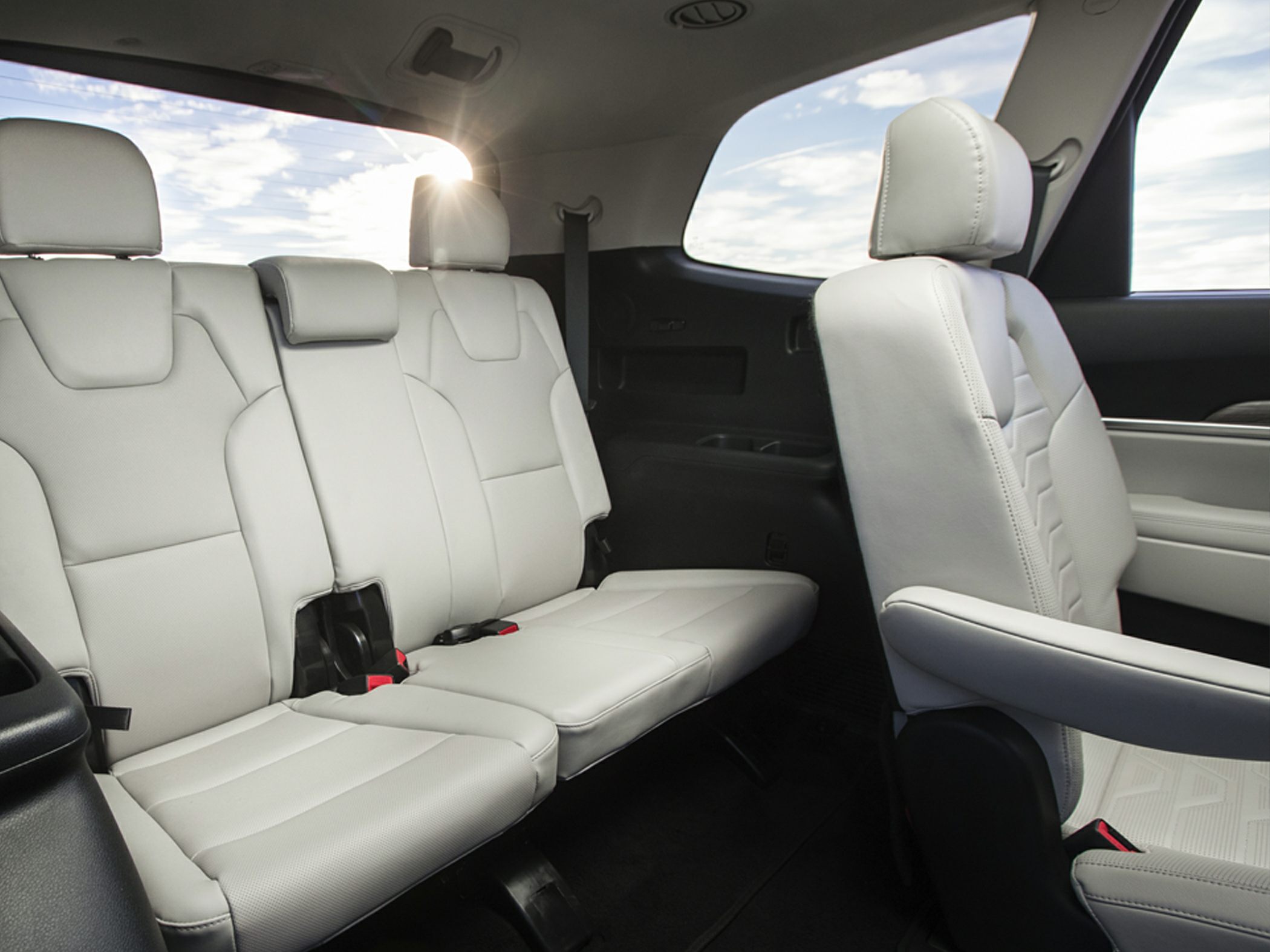 Interior rear and middle row seats with light upholstery and headrests