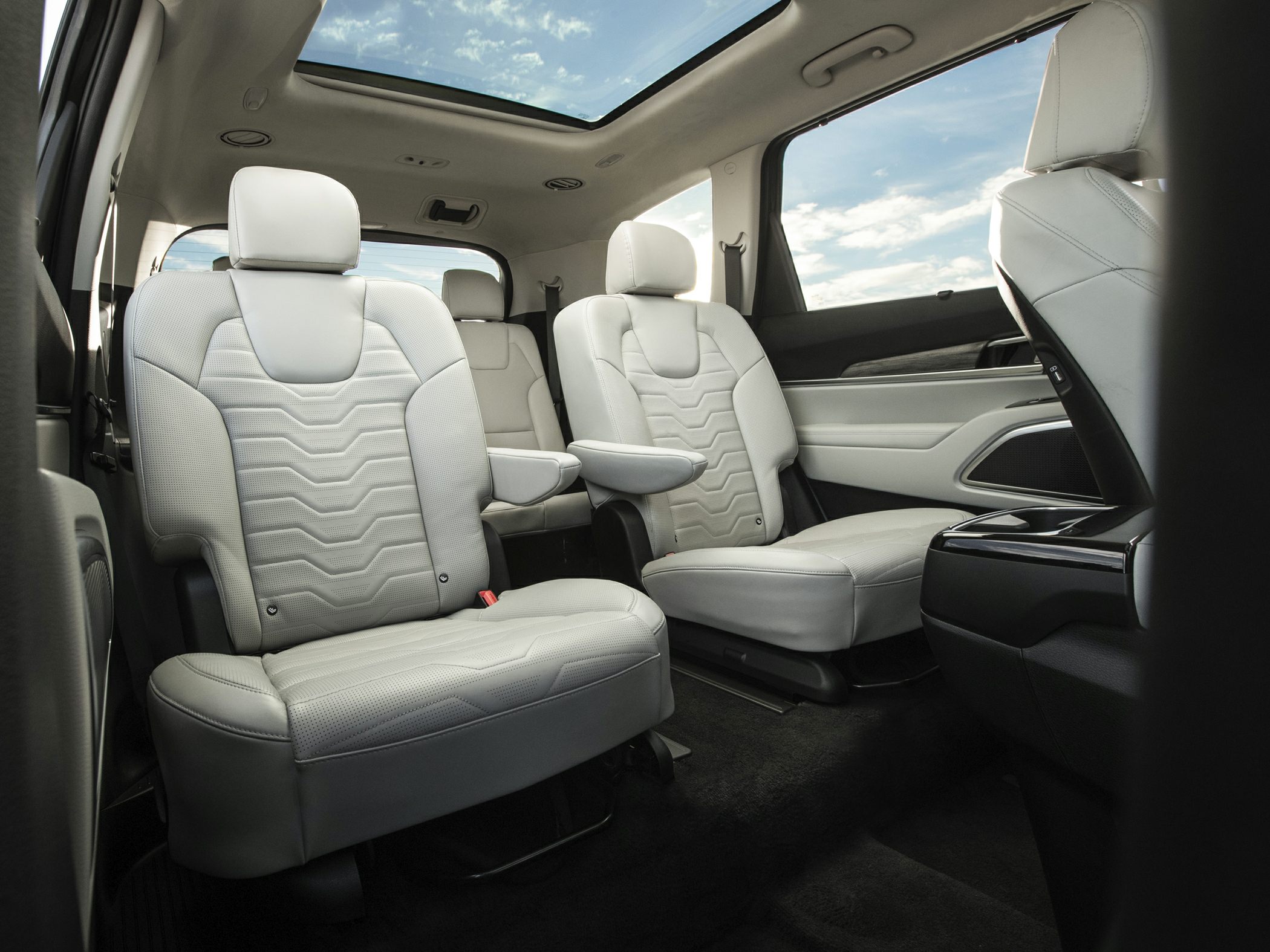 White leather captain chairs and panoramic sunroof in spacious SUV interior