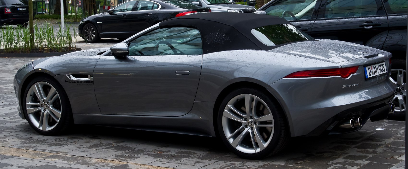 Silver convertible with black soft top and sporty rear design