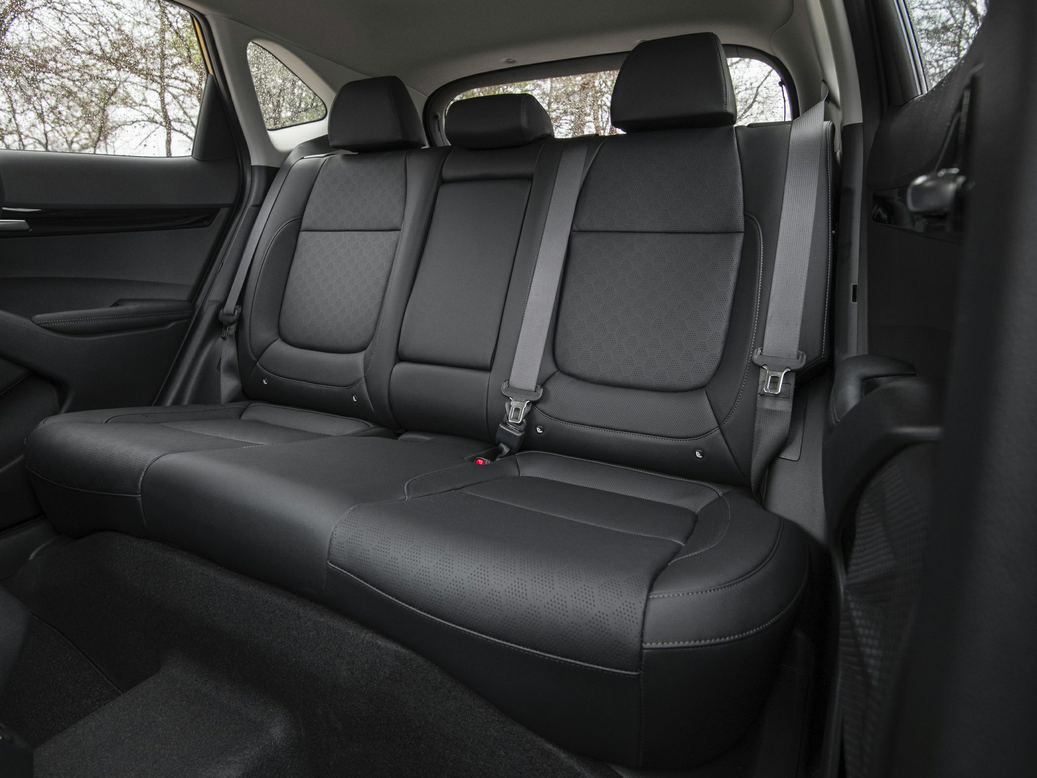 Black upholstered rear seat with integrated seat belts and headrests