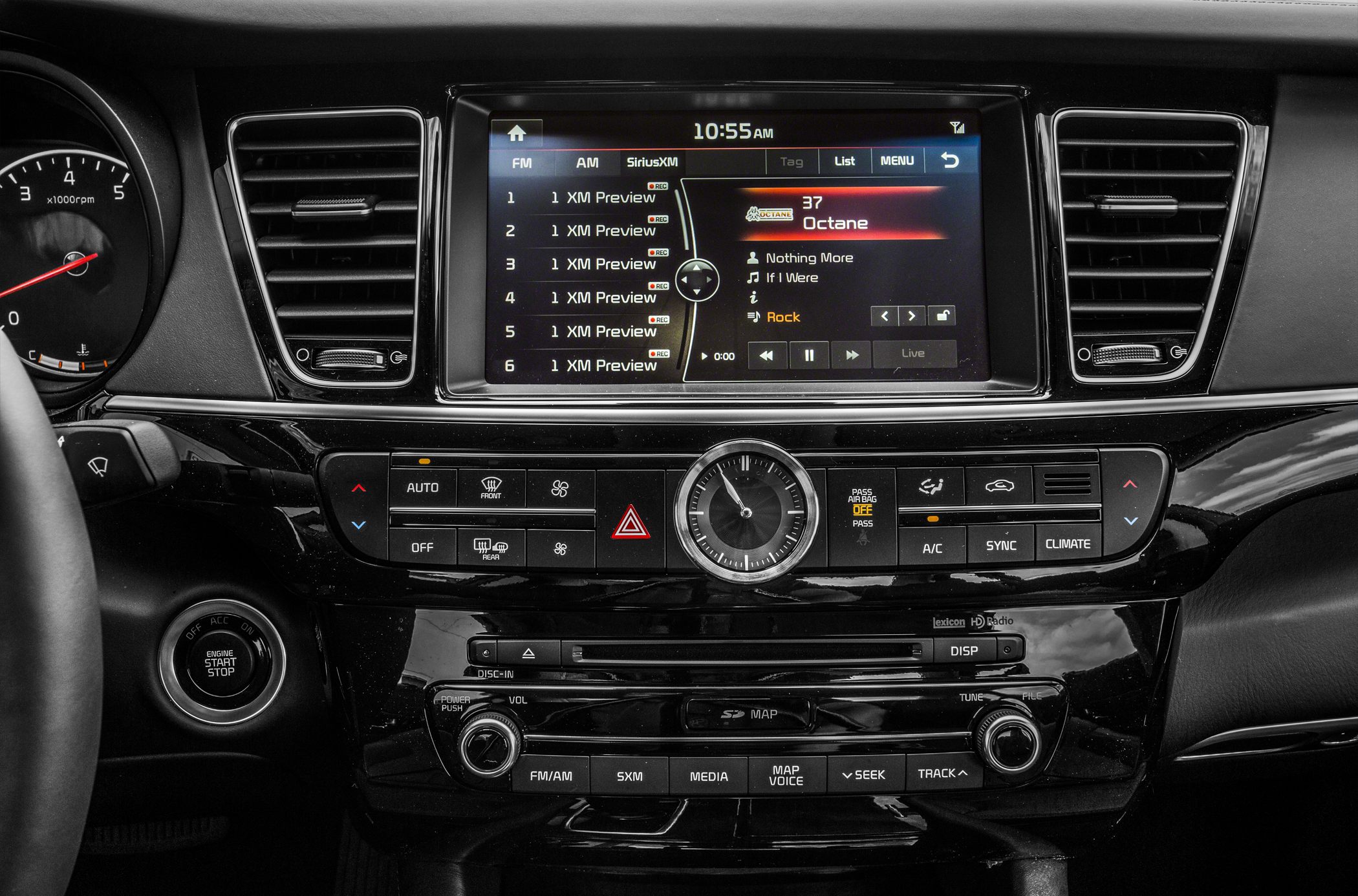 Car dashboard with infotainment screen, analog clock, and climate control panel