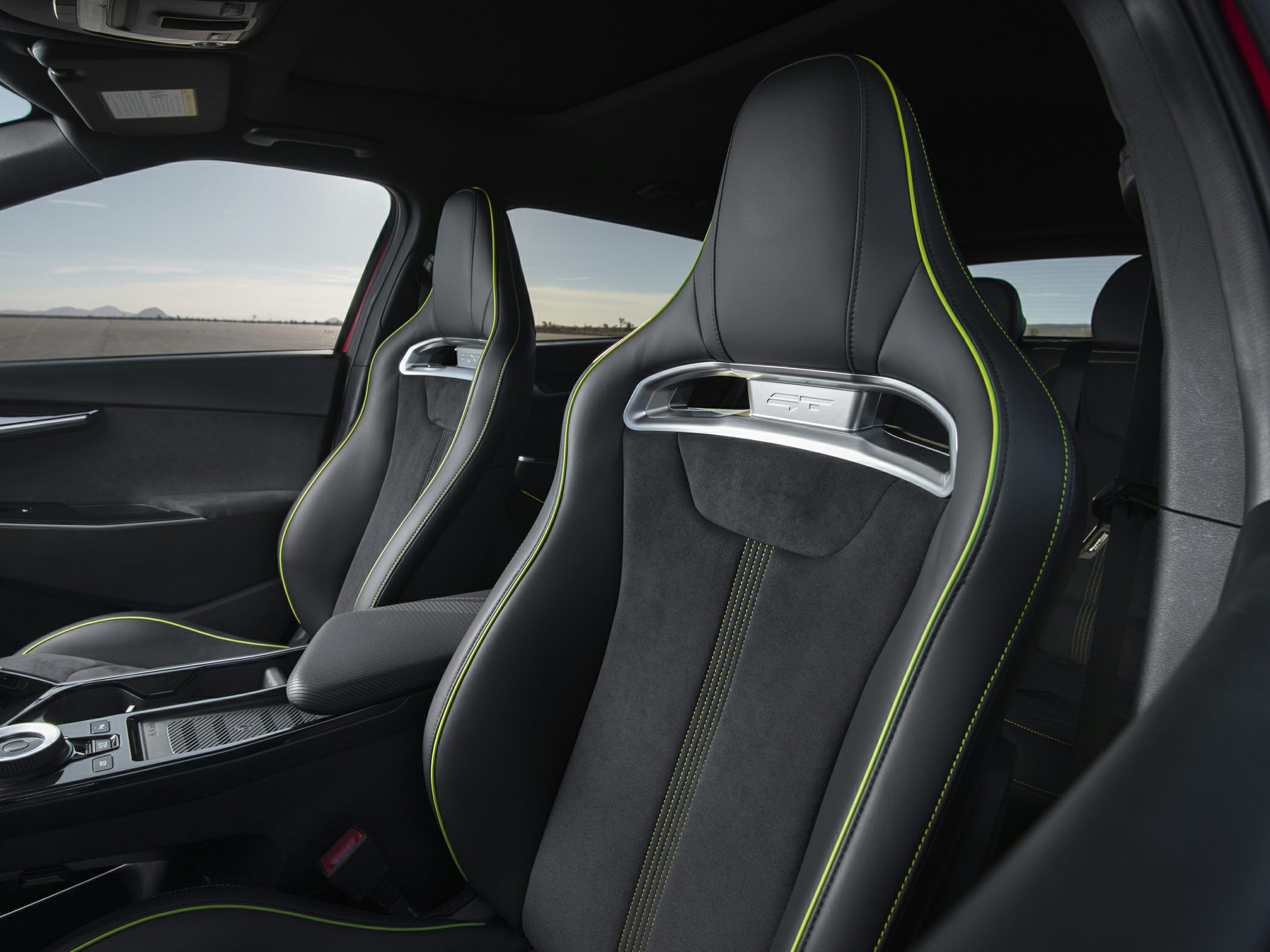 Sporty front seats with GT badge, black leather, and green contrast stitching