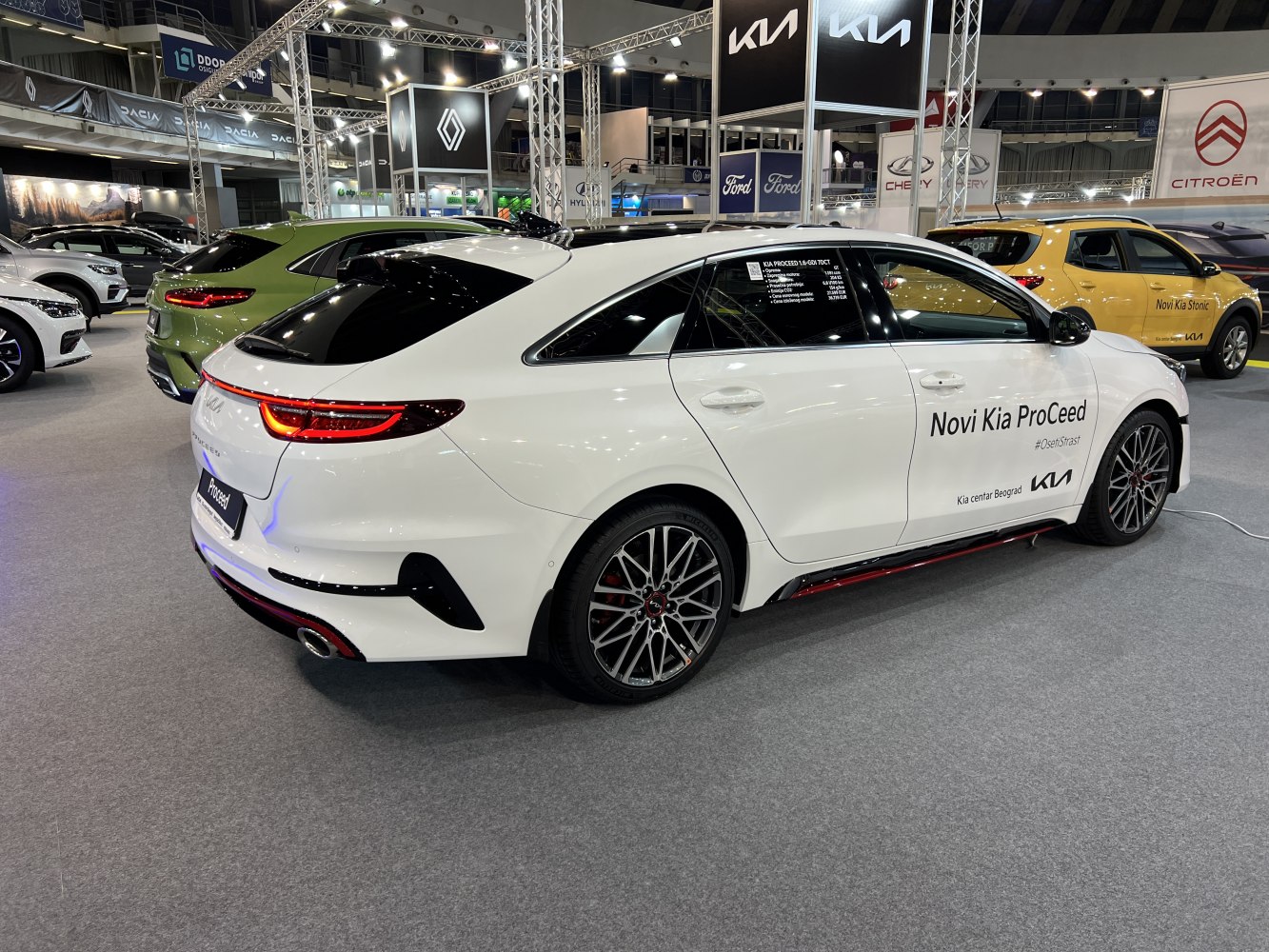 Rear-side view of white hatchback with sporty wheels and LED taillights.