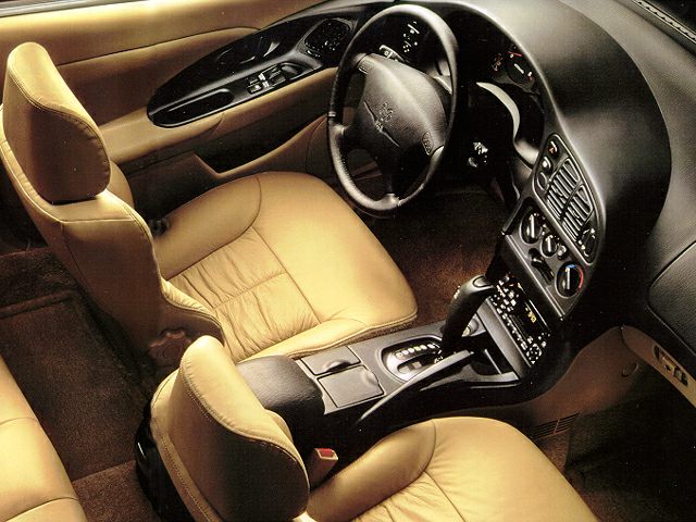 Tan leather seats and black dashboard with classic instrument panel