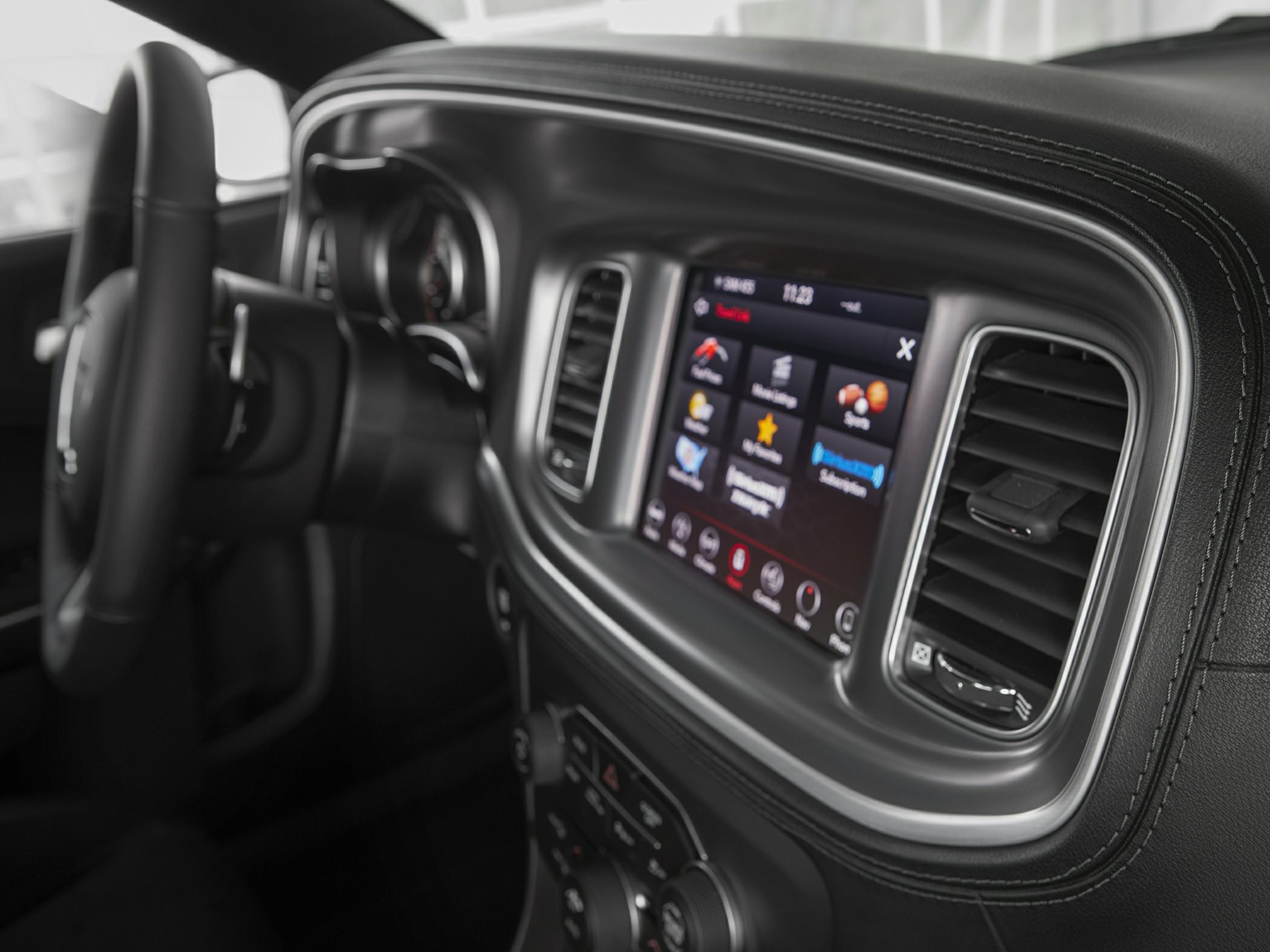 Touchscreen infotainment and dashboard details with air vents and steering wheel.