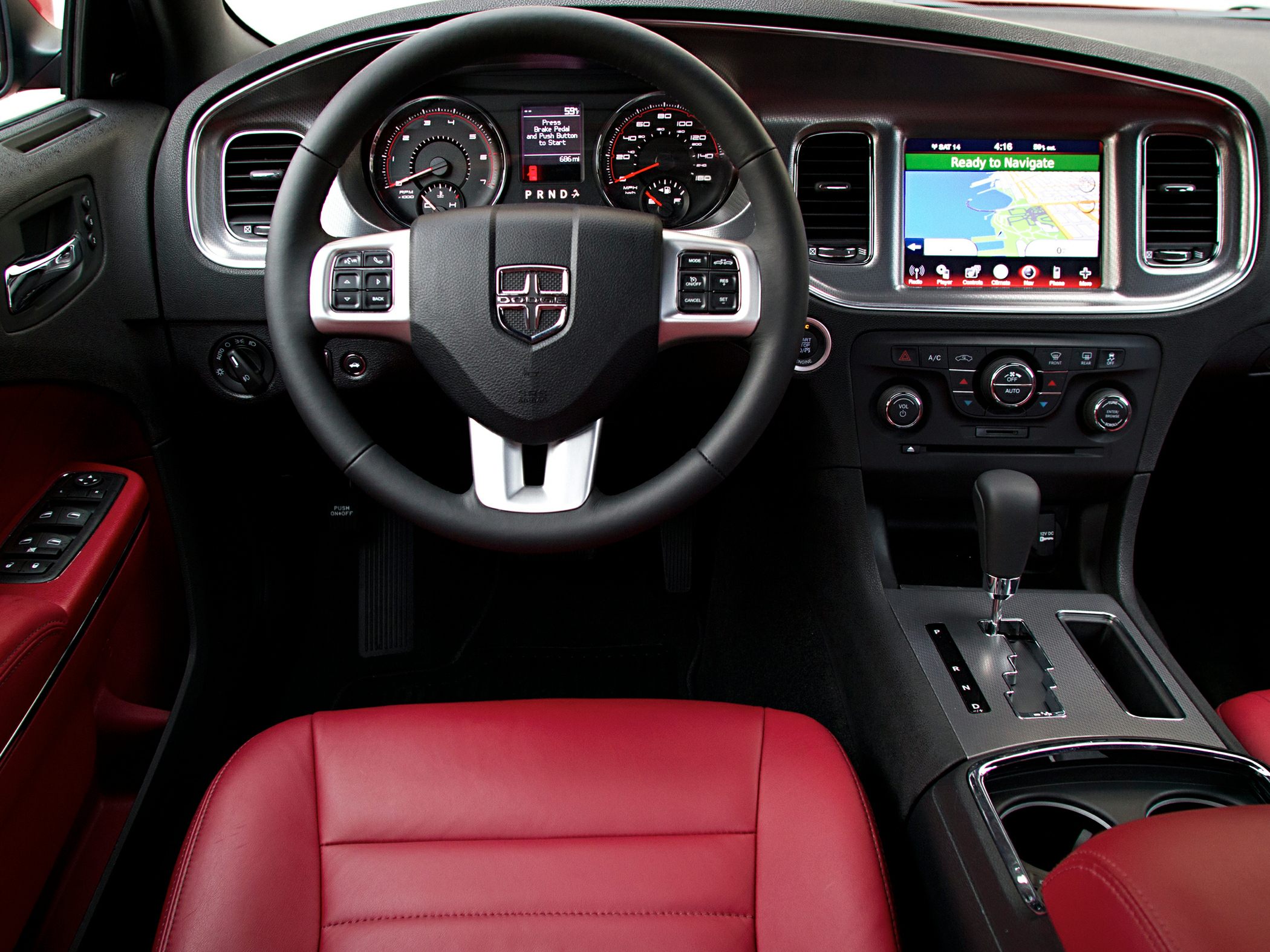 Dashboard with steering wheel, infotainment screen, and red leather seat