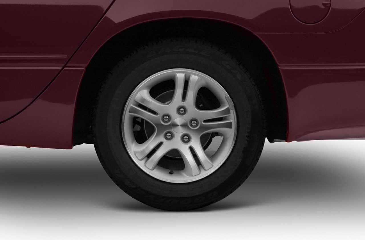 Alloy wheel and tire close-up on a maroon vehicle.