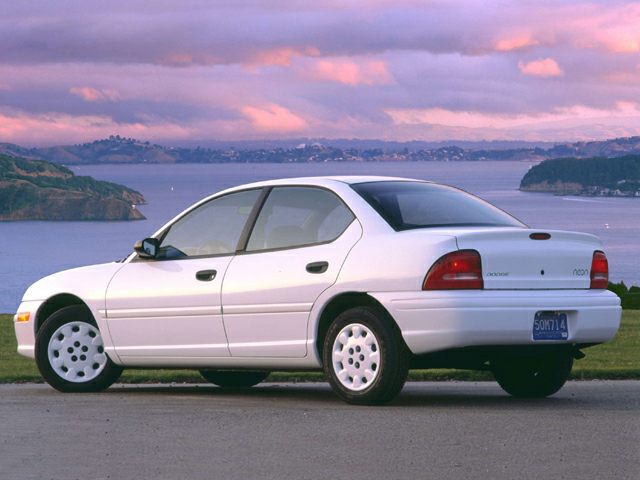 Rear and side view of a compact four-door sedan with smooth lines and classic 90s styling.