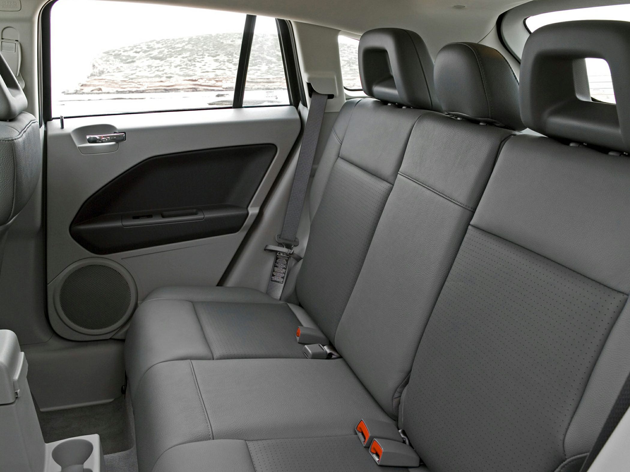Rear seat interior with black leather upholstery and seatbelts
