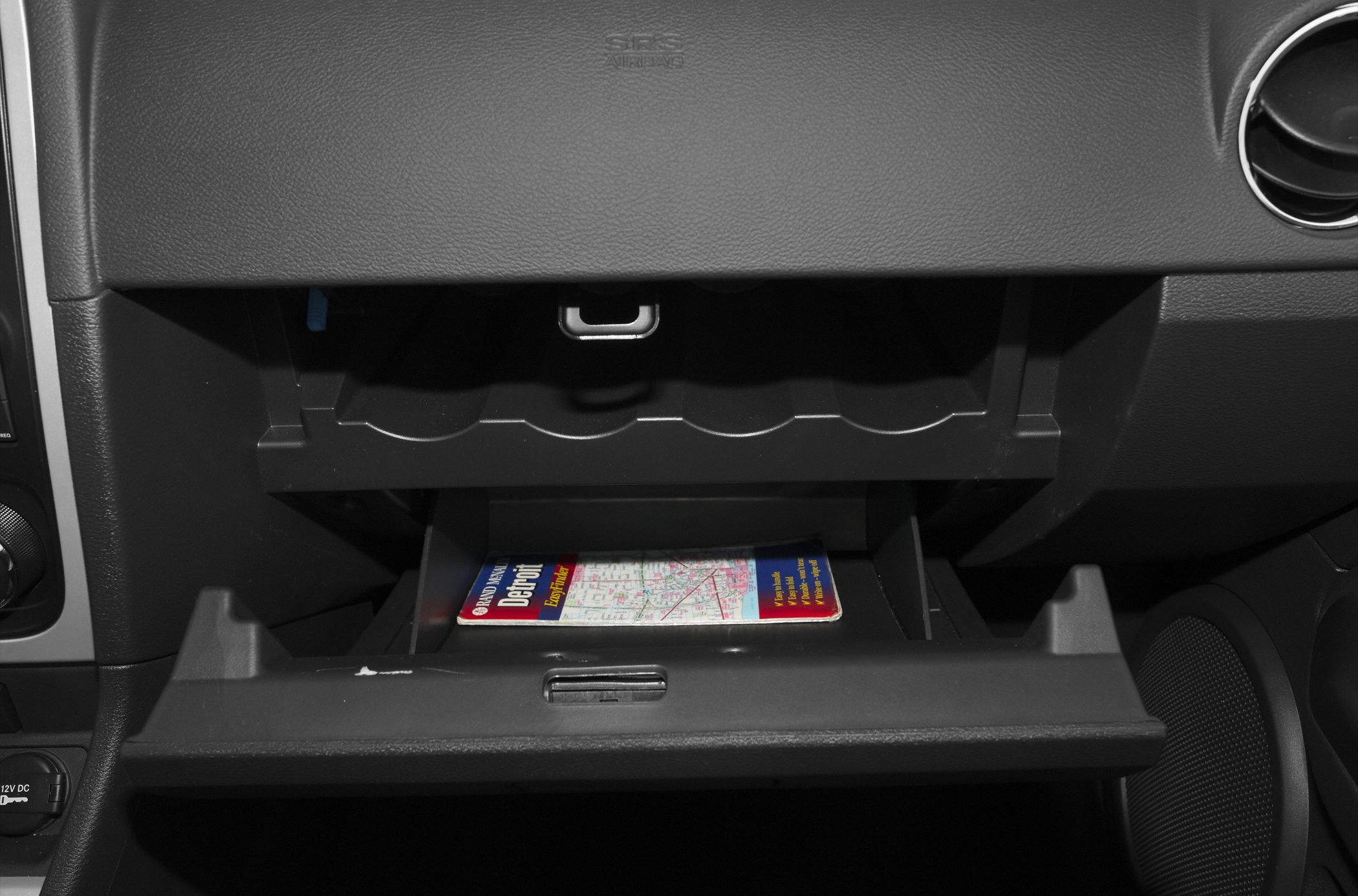 Open glove compartment with storage tray inside car dashboard