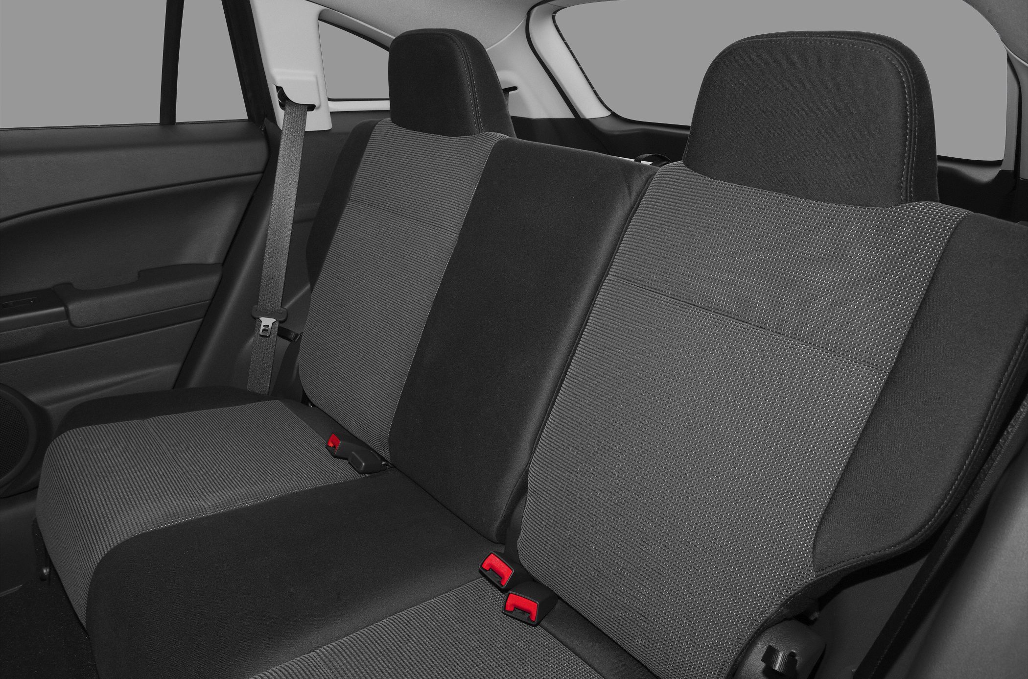 Rear seat interior with fabric upholstery and red buckle accents