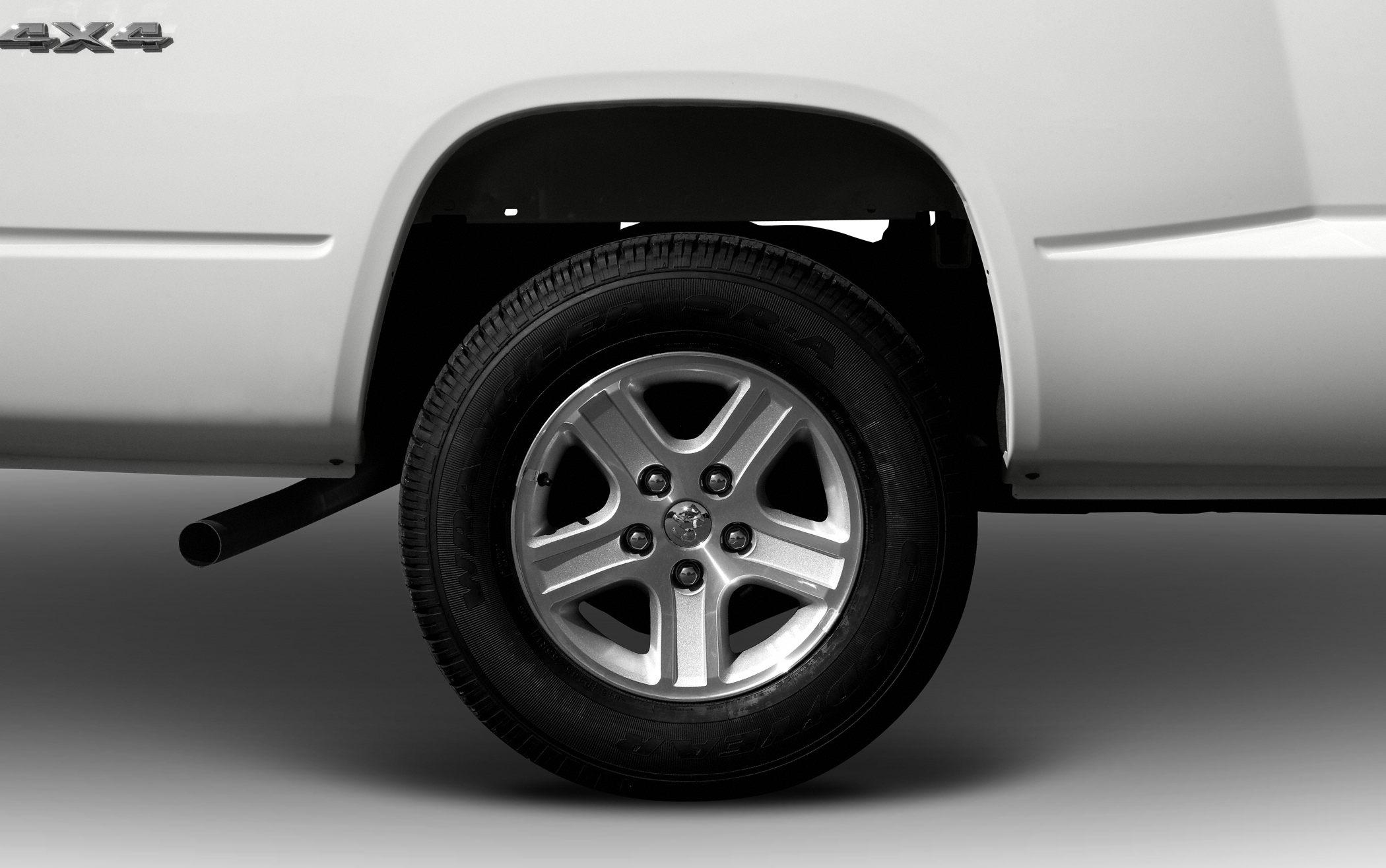 Close-up of rear wheel, alloy rim, tire, and 4x4 badge on truck fender