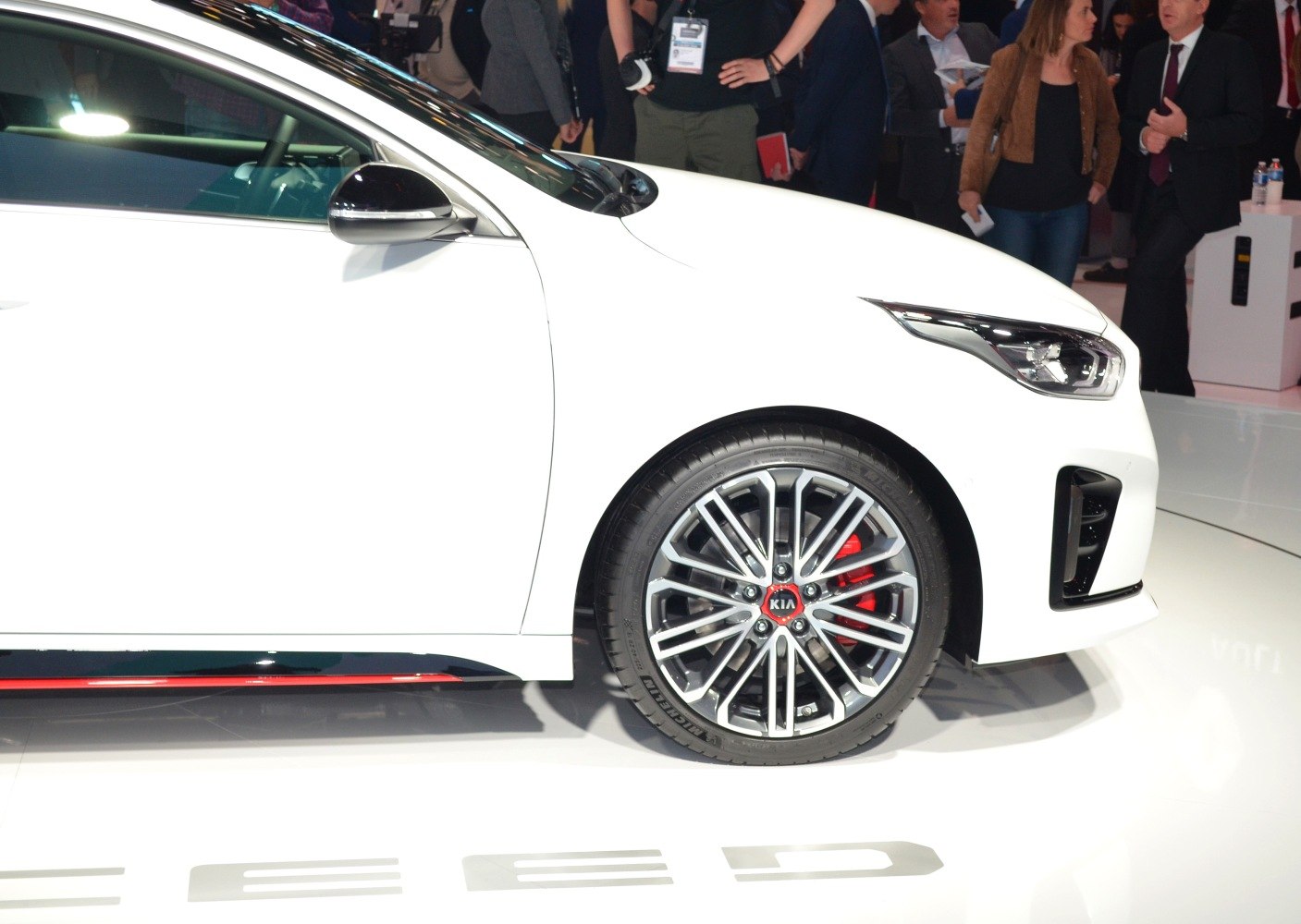Sporty alloy wheel with red brake caliper and sleek headlight close-up