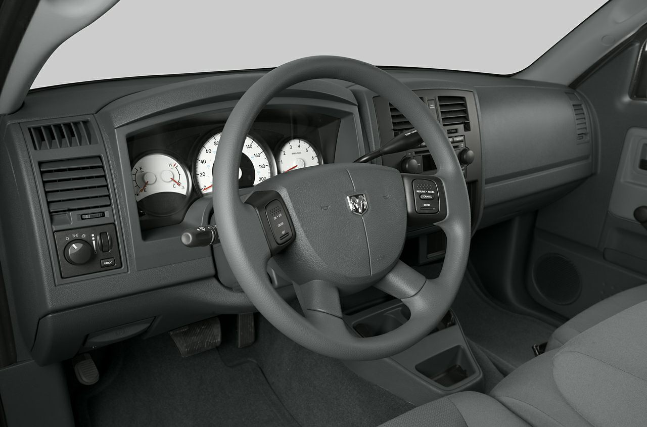 Steering wheel with controls and instrument cluster featuring speedometer and gauges.