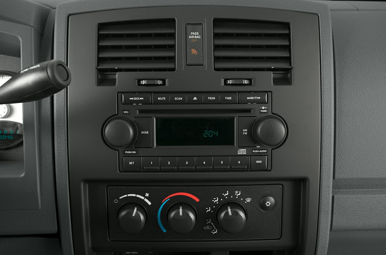 Dashboard audio system with climate control knobs and passenger airbag indicator.