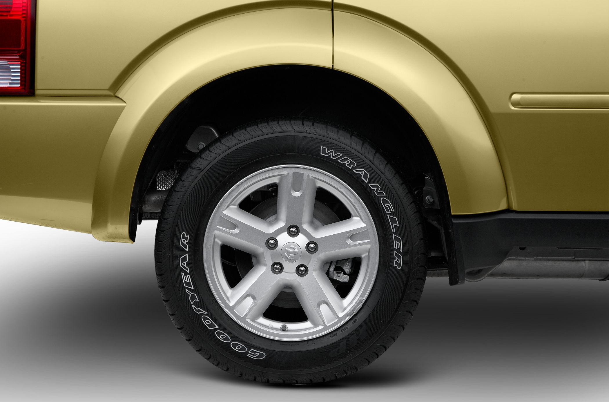 Alloy wheel with Goodyear Wrangler tire on vehicle.
