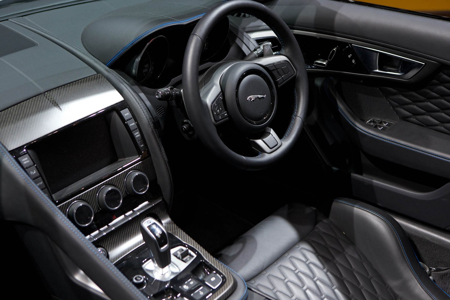 Luxury steering wheel and carbon fiber center console with premium stitched seats