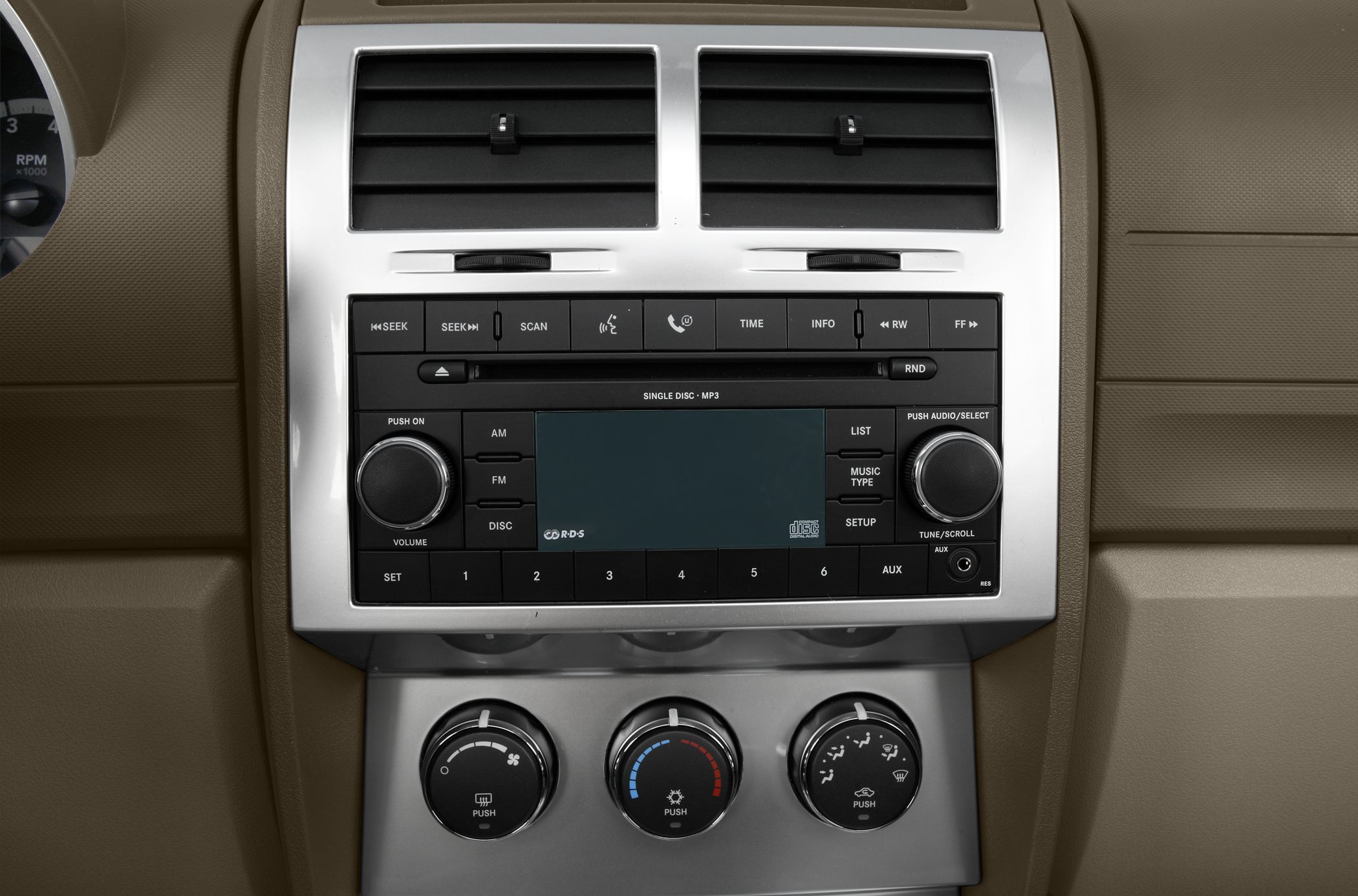 Car stereo and manual climate control knobs in beige dashboard.