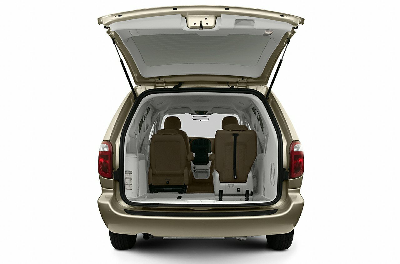 Rear cargo space with open hatch and two front seats in minivan